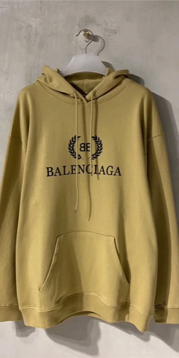 Real shot of the video - the top tested version of Balenciaga's classic wheat ear hooded sweatshirt. It is made of 480g pure cotton double-yarn terry fabric, which is thick and textured. It is made of high-density knitted fabric technology. It is firm and elastic, with high suppleness and skin-friendliness. It feels soft and delicate, does not shrink or deform, and has a crisp and stylish upper body. It is different from the cheap soft sofa fabrics with low weight and low count on the market.  Ultra-high-level workmanship, every detail shows a sense of luxury, and the original three-dimensional cutting process creates a perfect fit. The OS loose shoulder style accommodates all body types. It is a truly versatile style that looks slim and good-looking for both men and women.  The brushed classic wheat ear letter print has high fastness and will not crack or fall off. The classic pattern will never go out of style. Multiple colors are available, and every color is beautiful!  Color: Khaki Size: XS-L P:420