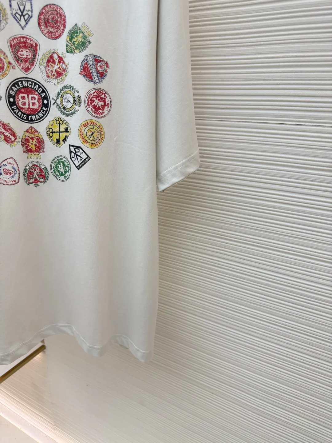 Balenciaga collection of trademark printed round neck short sleeves ●Original version: Purchased and developed at 3730 ●Item number: 1680781-A10 ●Fabric: Retro jersey fabric ●Technology: Glue printing ●Version: Loose version ●Weight: about 235 grams ●Size: Thread, 270g. 24S fabric is a medium-to-thick yarn, suitable for creating thick, crisp fabrics with a slightly rough texture, which is in line with the "natural and original" effect pursued by retro style. The texture is soft, breathable and elastic, suitable for close-fitting wear and able to create a simple and smooth silhouette. The loose silhouette design details with a retro feel are reflected through old textures, faded processing, and classic tailoring. Dark floral dot multi-layer overlay printing is an advanced printing technology that combines fine patterns and three-dimensional layers. Its core is to use high-mesh dot plate making to overprint transparent or light-colored printing paste on the fabric base multiple times with micron-level precision. Each overlay is accurately aligned to form a faint dark flower texture. The printing pattern does not rely on bright colors, but creates subtle light and shadow gradients and tactile layering on the surface of the fabric through the thickness difference of slurry accumulation and light refraction. The pattern shows subtle changes at different angles, combining visual depth and long-lasting washability. Oversize loose silhouette design, basic round neckline, dropped shoulder line, vertical pit woven code from top to bottom, collar, cuffs, and hem all have ruffles, and the sleeve length is longer to highlight the details. The thickness of the ready-made garment is the same as the original version, and it is additionally shaped to make the upper body wider and not easily deformed. The overall wiring is straight and delicate, the fabric is comfortable and soft, and the color is consistent without color difference. It can be matched with the same style to create a fashionable look and control various occasions. Customized accessories, complete with three standards, same style for men and women!