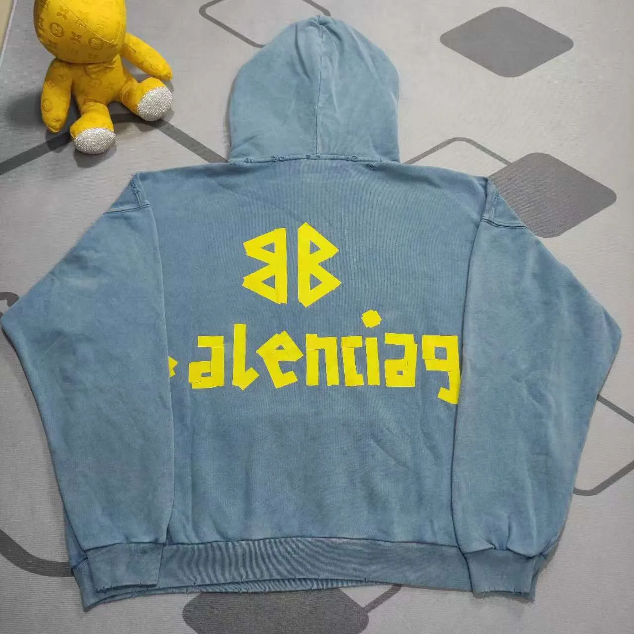 The top proven version of Balenciaga 23SS haze blue masking paper printed letters double-sided logo hooded loose hooded sweatshirt. This hoodie has a very interesting and cute design. The kangaroo pocket on the front of the large body is a reverse-cut design. The double side pockets are hollowed out, which actually deceives your vision when viewed from the front. The real pockets are sewn on the terry bottom on the reverse side. It is time-consuming and labor-intensive, but it is the core theme of the entire hoodie that cannot be ignored. In the same detail, the double side pockets are hemmed and stitched. And processed with holes; 480g heavy-weight pure cotton fabric with fine small terry bottom. After heavy mud dyeing and washing, the fabric still has a thick foundation and is comfortable and soft. The front and back double-sided textured paper transfer LOGO, and the front and back printing colors are different. The loose and large drop shoulder design is unisex. This style is also very suitable for girls to match. It is easy to create a lazy and casual street feel of the United States and France. Many holes are processed by hand grinding wheels on the body. Traces of muddying can be seen on the neckline, shoulder line, and side cuff splicing, but the visual effect transition is natural and soft without any sense of dirt. The old effect of the entire hoodie is excellent. The cuff threads are custom-woven in color; the packaging is washed and customized. The new gray silver letter main logo. The dropped shoulder model does not include shoulder width. The version is Kanye’s American style. Short and wide street casual version. From short sleeves to sweaters, this style is definitely not to be missed. Color: mud-dyed custom-woven navy Size: XS-S-M (Can be worn by both men and women, OS is loose and dropped on the shoulders) P:510