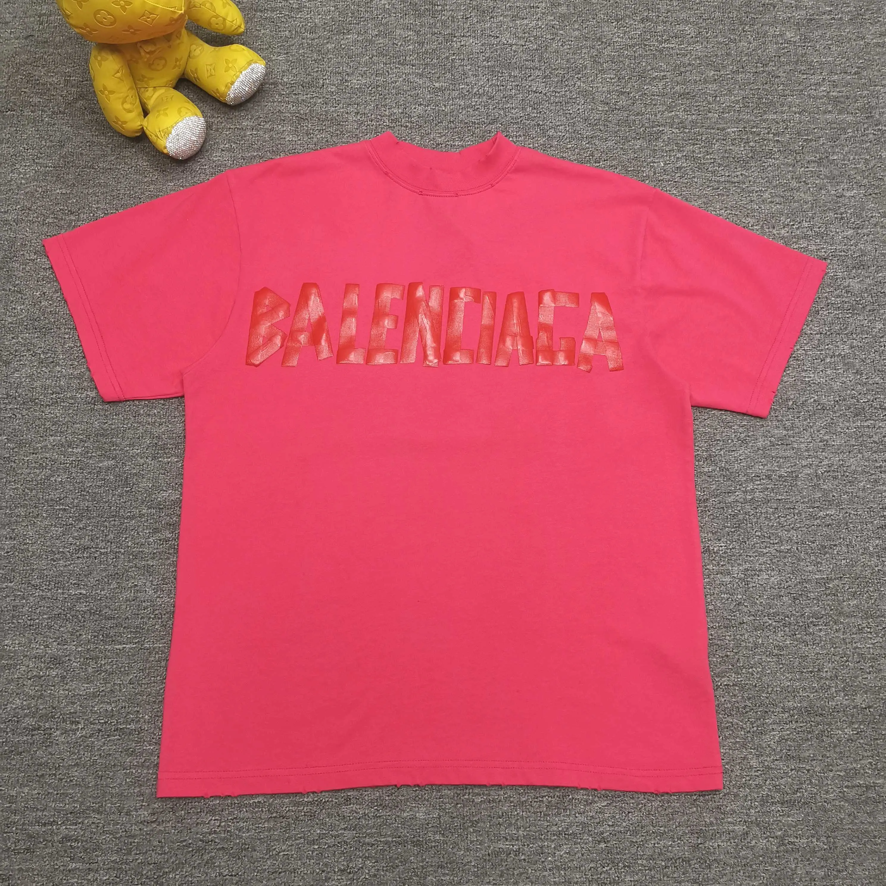Top tested version ❤️ Balenciaga tape new style rose red front and back letter masking tape short-sleeved T-shirt 280 grams full of texture, clean cloth, soft and comfortable. Solona thread dyeing without color difference. The fabric is made of 16s single yarn combed cotton plain weave. The original is custom-dyed in gray and black, and the front panel is printed using an elliptical machine screen + digital direct inkjet integrated machine. Imported environmentally friendly glue + transparent slurry is used as a base and the digital slurry is scraped twice. The color is printed using digital direct inkjet printing. According to the original refined artwork, the color is deepened at the connection position of the letters. The overall visual effect is like a hand-made decal on textured paper. The back panel is printed with fluorescent ink, and all hand-painted blurred strokes at the connecting positions of the letters make the letters more three-dimensional in the overall visual effect. The ready-made garments are hand-worn and cut out, and softeners are added to sand-wash, stir-fry, make the color old and soft. os dropped shoulders, loose version, same style for men and women. Color: Rose Red Size: XS-L P:280