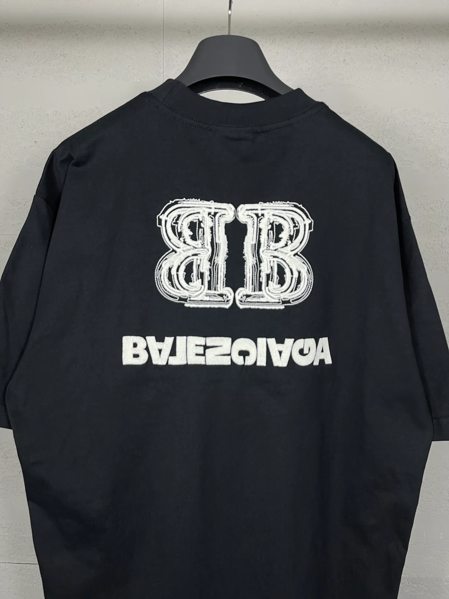 🅿️200 Actual pictures [Top version. Official website quality] BALENCI*GA/Paris BALENCI*GA# New style, BB reverse letter embroidery letters large LOGO short-sleeved T-shirt. More than 200,000 needles are used to embroider the logo letters on the front and back of the chest. Welcome to compare! The fabric is made of Paris ZP custom-woven and dyed 100% cotton double-yarn compact cotton. The weight is 260 grams. The cloth surface is clean. The cloth pattern is clear. It is soft and comfortable. It has good color fastness and is not easy to change color. The threads are woven and dyed with no color difference. The embroidery is done using imported Tajima embroidery machines. Super 15W needle thread embroidery, accurate positioning, three-dimensional effect, clear lines. No burrs and miscellaneous threads, ultra-high craftsmanship embroidery. The version adopts OS loose shoulder design. Same style for men and women. Code: BL223208 Color: black. Size: XS to L