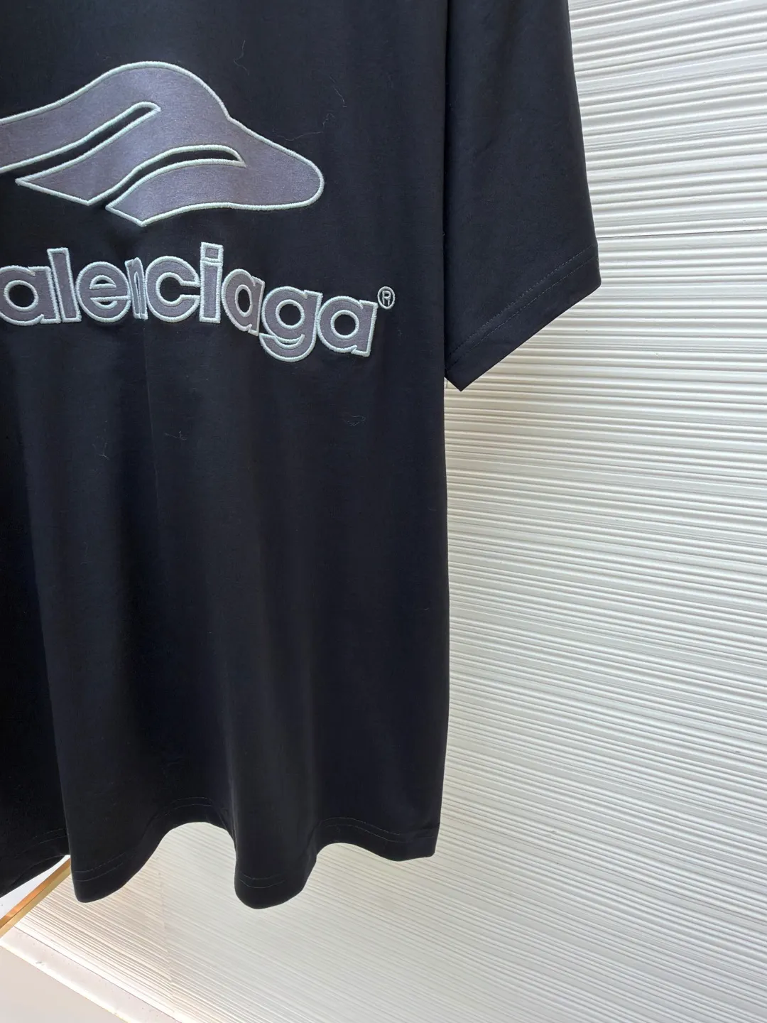 Balenciaga Team Series V-neck Short Sleeve ●Original version: Purchased and developed by 6898 ●Item No.: 1682042-A50 ●Fabric: Jersey compact cotton fabric ●Technology: Glue printing ●Color: Black ●Version: Loose version ●Weight: about 310 grams ●Size: Compact spinning technology is applied in the spinning process, which significantly reduces yarn hairiness and makes the yarn smoother and stronger. This gives the fabric an unusually dense structure, a smooth and smooth surface, and excellent pilling resistance, while retaining the softness and breathability of pure cotton. The weight of 185g is light to middleweight, ensuring that the clothing is light, drapeable and can move freely. It is very suitable for creating a long-sleeved shirt that combines sportiness with daily comfort. The V-neck part is made of two different colors of high-elastic rib fabrics. The process step is to first weave ribbed belts of two colors separately, and then through precise cutting and splicing, form a V-shaped neckline with sharp color contrast. It breaks the monotony of the solid color body, uses strong color contrast to create a young and energetic visual focus, and optimizes the neck line. The pattern is pre-cut and formed into patches on fabrics of different materials or colors, and then covered on the body. Finally, high-density embroidery thread is used to fix the edges and outline the internal details. Its function is to create patterns with bright colors, strong texture contrast, three-dimensionality and durability. The edges of the pattern are strong and not easy to wear. A special elastic paste is screen-printed on the sleeves to create brightly colored patterns with a slightly coated feel. The elastic paste ensures that the printed area can stretch with the fabric without cracking. It forms a texture contrast between one flat and one convex with the three-dimensional sense of appliqué, which increases the interest and complexity of the design. The overall wiring is straight and delicate, the fabric is comfortable and soft, and the color is consistent without color difference. It can be matched with the same style to create a fashionable look and control various occasions. Customized accessories, complete with three standards, same style for men and women!