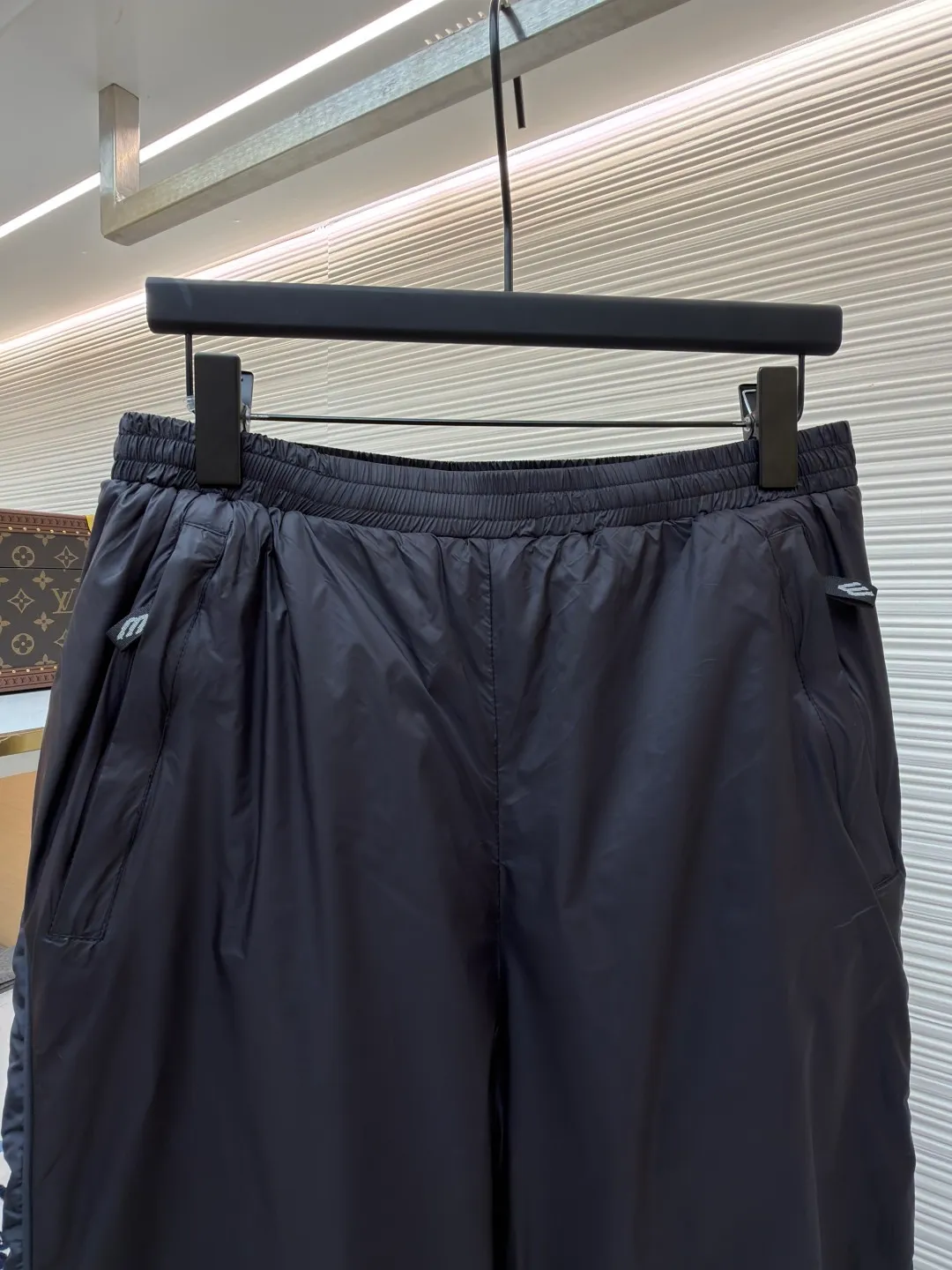 Balenciaga SKIWEAR series 3B printed fleece ski pants ●Original version: purchased and developed by 12414 ●Item number: 1682492-B25 ●Fabric: nylon fabric ●Technology: printing production ●Color: black ●Version: fitted version ●Weight: about 415 grams ●Size: S-M-L-XL ●Description: High-density technological nylon fiber is selected, and a delicate matte texture is created through a special textile process. The black tone presents a low-key and high-end visual effect. The fabric is lightweight yet stiff, has excellent wrinkle resistance and abrasion resistance, and is not prone to pilling or deformation for daily wear. It also has certain windproof properties to cope with changeable weather. The inner lining is made of high-density fluff material with excellent fluffiness and elasticity. When it closely fits the skin, it can form a layer of warm air, effectively locking in heat and improving the warmth factor of winter wear. The down fiber is delicate and smooth, avoiding the rough feeling of traditional plush fabrics, achieving the dual experience of "lightness and no burden" and "constant temperature and warmth", taking into account both comfort and practicality. Imported silicone printing technology is used on both sides of the trouser legs to present the iconic 3B sports icon pattern in a relief-like three-dimensional form. The silicone material has been pressed at high temperature and is tightly integrated with the fabric, making it difficult to fall off and crack. At the same time, it retains a delicate matte luster, forming a subtle texture contrast with the pants fabric, highlighting the brand recognition in a low-key manner. The mid-waist design is equipped with a double-layer elastic rib waistband and a built-in adjustable drawstring. The elastic fiber at the waistband has been pre-shrunk to ensure that it is not easy to loosen after long-term wear. It can not only stabilize the waist shape, but also adapt to the activity needs of different body shapes, taking into account sports functionality and daily comfort. The overall wiring is straight and delicate, the fabric is comfortable and soft, and the color is consistent without color difference. It can be matched with the same style to create a fashionable look and control various occasions. Customized accessories, complete with three standards, same style for men and women!