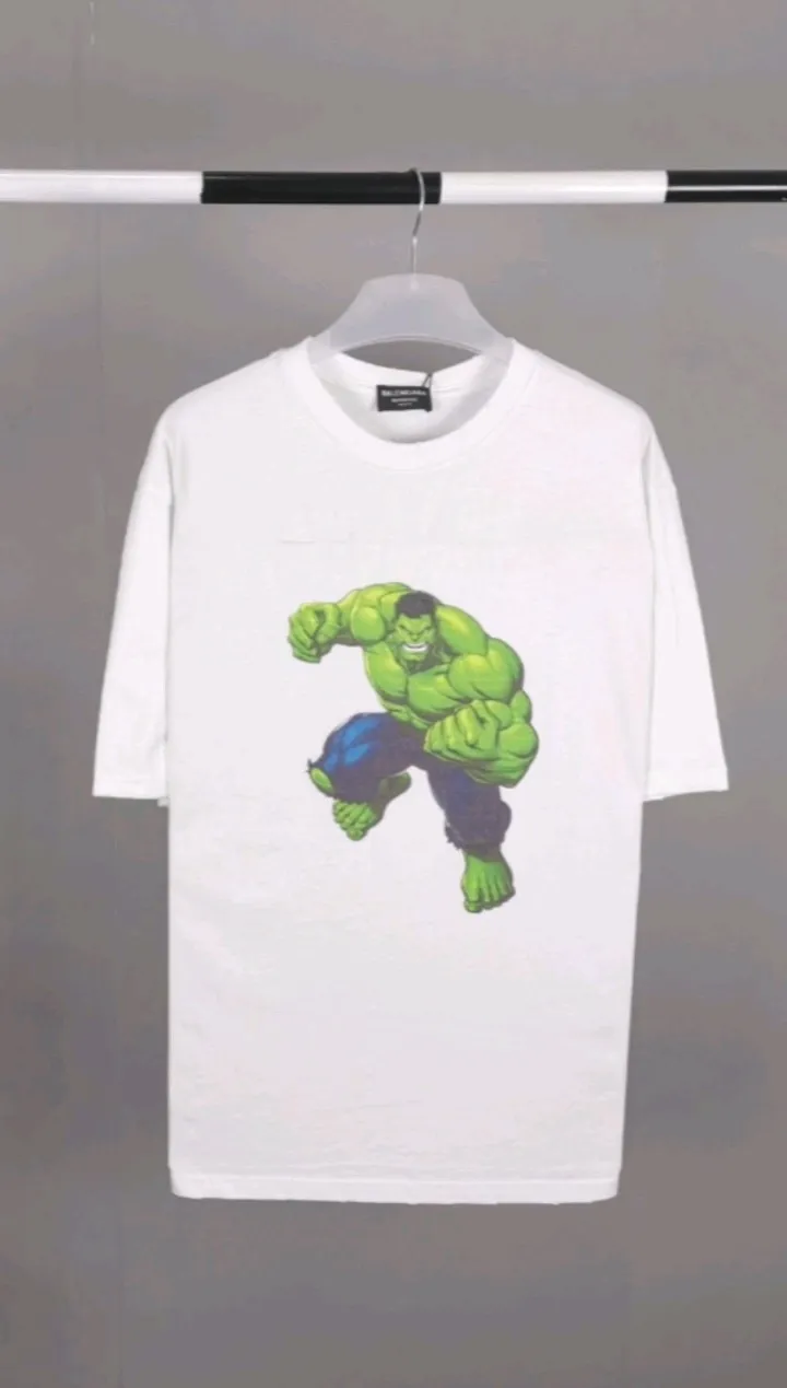 Real shot of the video————The strongest Balenciaga/Balenciaga Heavy Industry washed Hulk Marvel joint short-sleeved fabric is made of double yarn plain weave, 280g sweatshirt fabric; matched with 32S/1*2 fine cotton double yarn 1*1 rib, washed environmentally friendly custom-dyed fabric, and the threads are in the same vat with no color difference.  The front printed green giant uses water-wash printing technology; it is made of imported environmentally friendly glue material (no odor) and mechanized printing technology. Mechanical printing has high precision, the positioning accuracy can reach ±0.02mm, the quality is stable, and the printing quality is clear, just like the photo. The body is washed and frayed and embroidered elements are added, which greatly increases the interest of the clothing; it has a unique visual effect. The special washing effect creates a unique aged effect. A unisex style that blurs the boundaries, with a classic dropped shoulder and oversize silhouette, and a loose and casual upper body. Color: Black Size: XS-L P:260