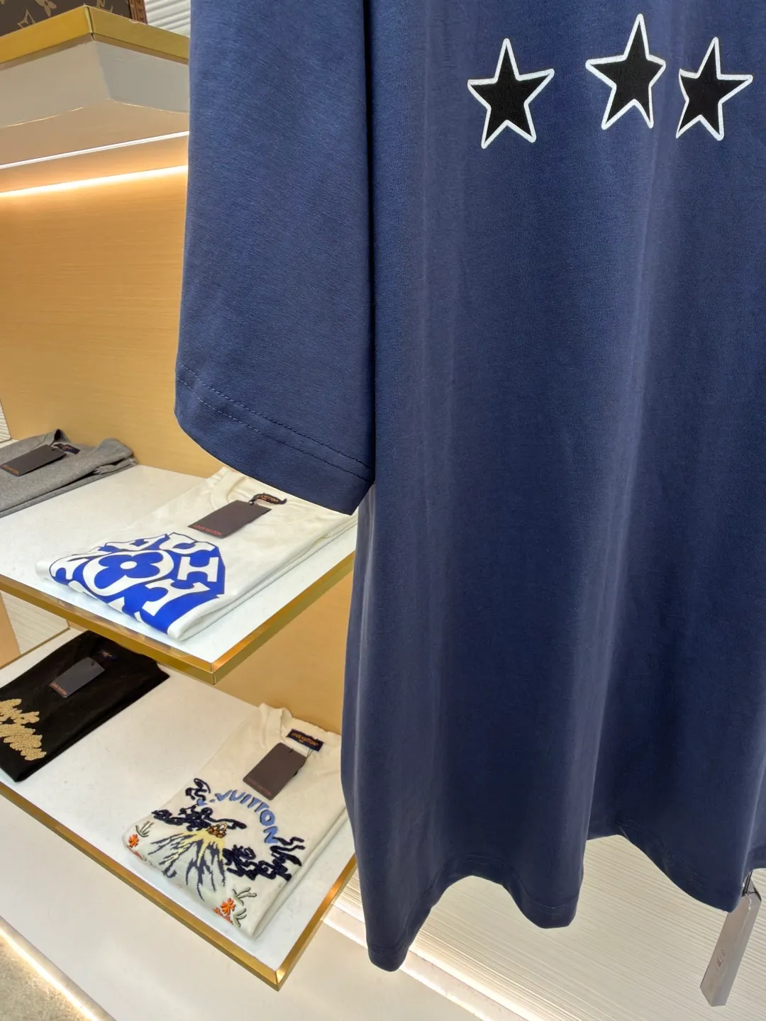 Balenciaga star embroidered short sleeves [comes with marker] ●Item number: 1682275-A20 ●Material: combed cotton fabric ●Technology: embroidery printing ●Color: blue ●Version: loose fit ●Weight: about 355 grams ●Size: XS-S-M-L ●Description: This navy blue short-sleeved T-shirt is made of high-density piqué mesh cotton fabric. The fabric has been custom-woven and dyed. The navy blue tone is uniform and not easy to fade. The breathable structure formed by the piqué texture makes the wearer more refreshing. At the same time, the fabric has excellent stiffness and can support the loose shoulder silhouette. The five-star pattern on the chest adopts double-track offset printing + inlay embroidery process. First, the outline of the stars is outlined with high-temperature embossing using matte silicone material. The thickness of the silicone layer is controlled at 0.3mm to ensure softness and no irritation to the skin. White embroidery thread is then used to fill in inlay along the edge of the silicone to give the star pattern a three-dimensional relief texture. The stitch density of each star reaches 12 stitches/cm, and the pattern alignment error does not exceed 0.1cm. The neckline is designed with a small stand-up collar, which is woven with ribs of the same fabric. It is not easy to loose after high-temperature pre-shrinking treatment. The side seams are spliced ​​with a seamless buried clip process to reduce friction when wearing. The overall process takes into account the texture and wearing comfort. The overall wiring is straight and delicate, the fabric is comfortable and soft, and the color is consistent without color difference. It can be matched with the same style to create a fashionable look and control various occasions. Customized accessories, complete with three standards, same style for men and women!