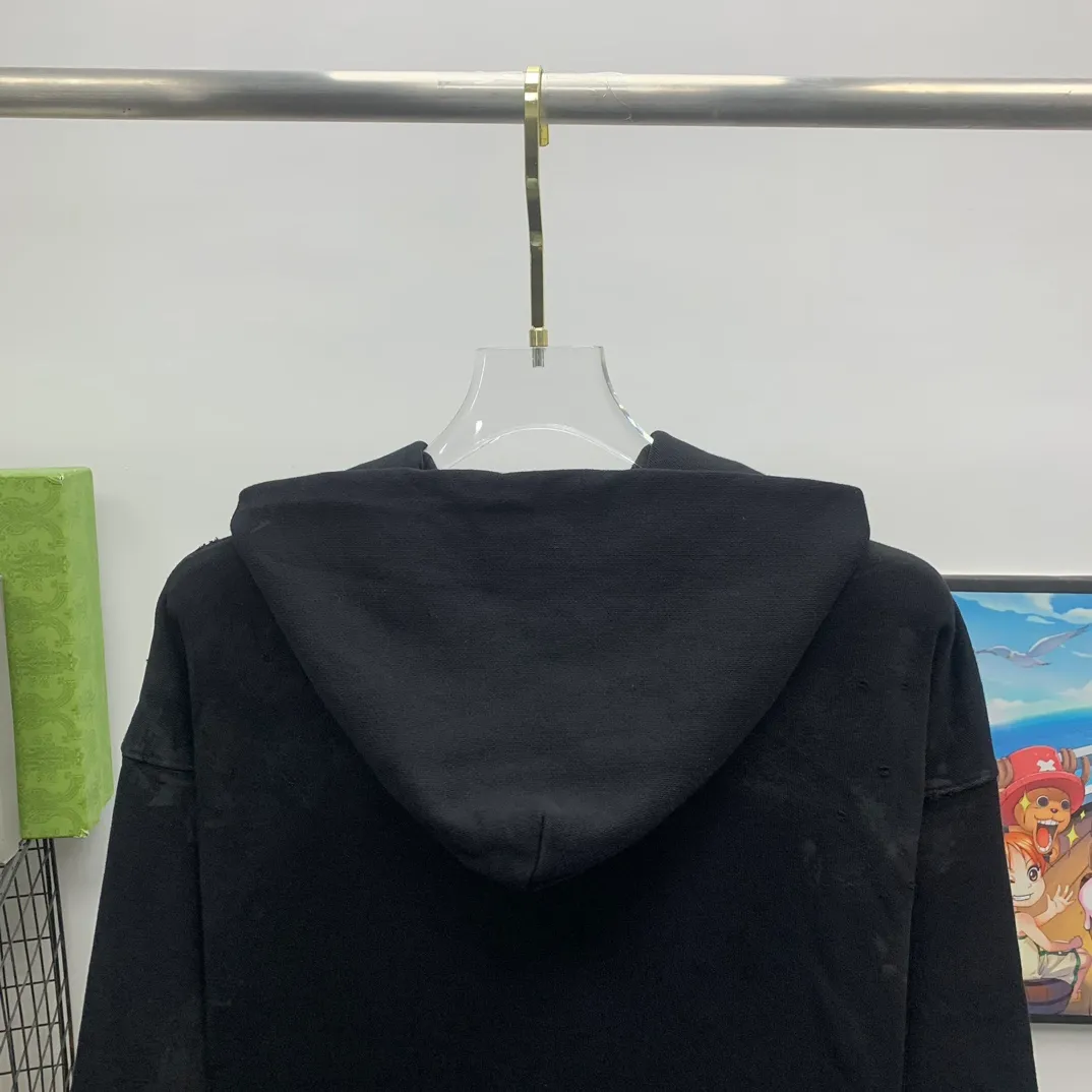 Top tested version 23FW BALENCIAGA Paris Manchester United limited edition distressed male and female couple star same style pure cotton loose hooded sweatshirt [very suitable for Douyin, and other platforms! The letters in the LOGO position have been damaged and polished! 】 The fabric is custom-made washed knitted cotton terry material. The upper body is very soft. The front panel uses a classic hand pocket with a worn effect. The overall yellow and dirty effect is all artificially sprayed with majolica. It requires proficiency and experience to achieve this natural and elegant effect!  Customized towel embroidery on the chest, heavily damaged! The aging effect is very obvious! The overall artificial positioning coating is hand-made, washed and dirty. The frayed hole craftsmanship has a hand-painted graffiti effect. The arms behind the bend are made of open-stitch frayed craftsmanship. The wiring is delicate. Elastic cuff design. The whole body is hand-positioned with muddy dyeing and frayed effect! Ready-made garments are washed twice with water +➕ once with wax. It feels smooth!   The Manchester United letters and logo on the chest are designed with full embroidery and the details are visible!  Size: XS-L Color: White Black P: 470