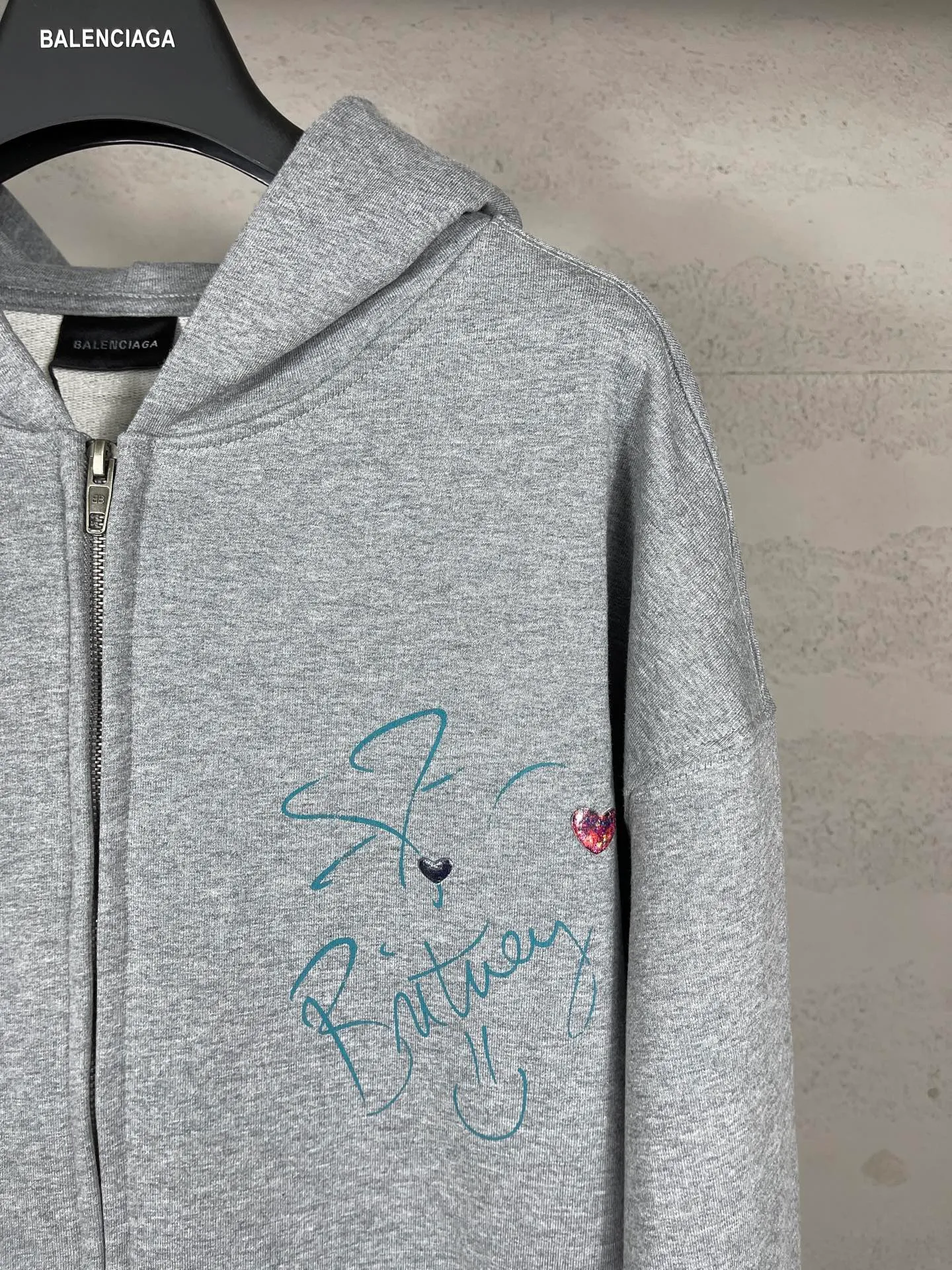 🅿️390 real photos [Top version. Official website quality] BALENCI*GA/26 new model. Balenciaga Music |Britney Series limited edition music collaboration series, front and back direct-print printing, embroidered hat, zipper hooded cardigan and sweatshirt, SS26 latest style. Research and development at the first time, different market currencies. Comparisons welcome. The fabric is made of Paris ZP custom-woven and dyed cotton sweatshirt, with a weight of 460 grams. The cloth surface is clean. The cloth pattern is clear, soft and comfortable. The threads are dyed with no color difference. Printing adopts computer direct printing. The embroidery is done using imported Tajima embroidery machines. Jubie market currency. Welcome to compare. The version adopts OS loose shoulder design. Same style for men and women. Code: BL259958 Color: Gray Size: XS S M L