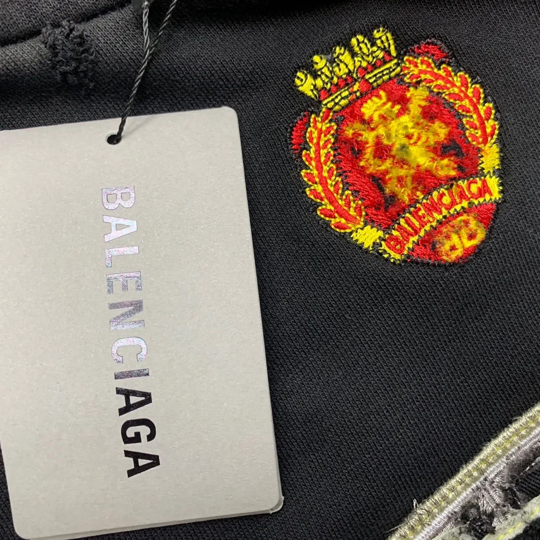 Additional details————Top-level verified version 23FW BALENCIAGA Paris Manchester United limited edition distressed male and female couple star same style pure cotton loose hooded sweatshirt [very suitable for Douyin, and other platforms! The letters in the LOGO position have been damaged and polished! 】 The fabric is custom-made washed knitted cotton terry material. The upper body is very soft. The front panel uses a classic hand pocket with a worn effect. The overall yellow and dirty effect is all artificially sprayed with majolica. It requires proficiency and experience to achieve this natural and elegant effect!  Customized towel embroidery on the chest, heavily damaged! The aging effect is very obvious! The overall artificial positioning coating is hand-made, washed and dirty. The frayed hole craftsmanship has a hand-painted graffiti effect. The arms behind the bend are made of open-stitch frayed craftsmanship. The wiring is delicate. Elastic cuff design. The whole body is hand-positioned with muddy dyeing and frayed effect! Ready-made garments are washed twice with water +➕ once with wax. It feels smooth!   The Manchester United letters and logo on the chest are designed with full embroidery and the details are visible!  Size: XS-L Color: White Black P: 470