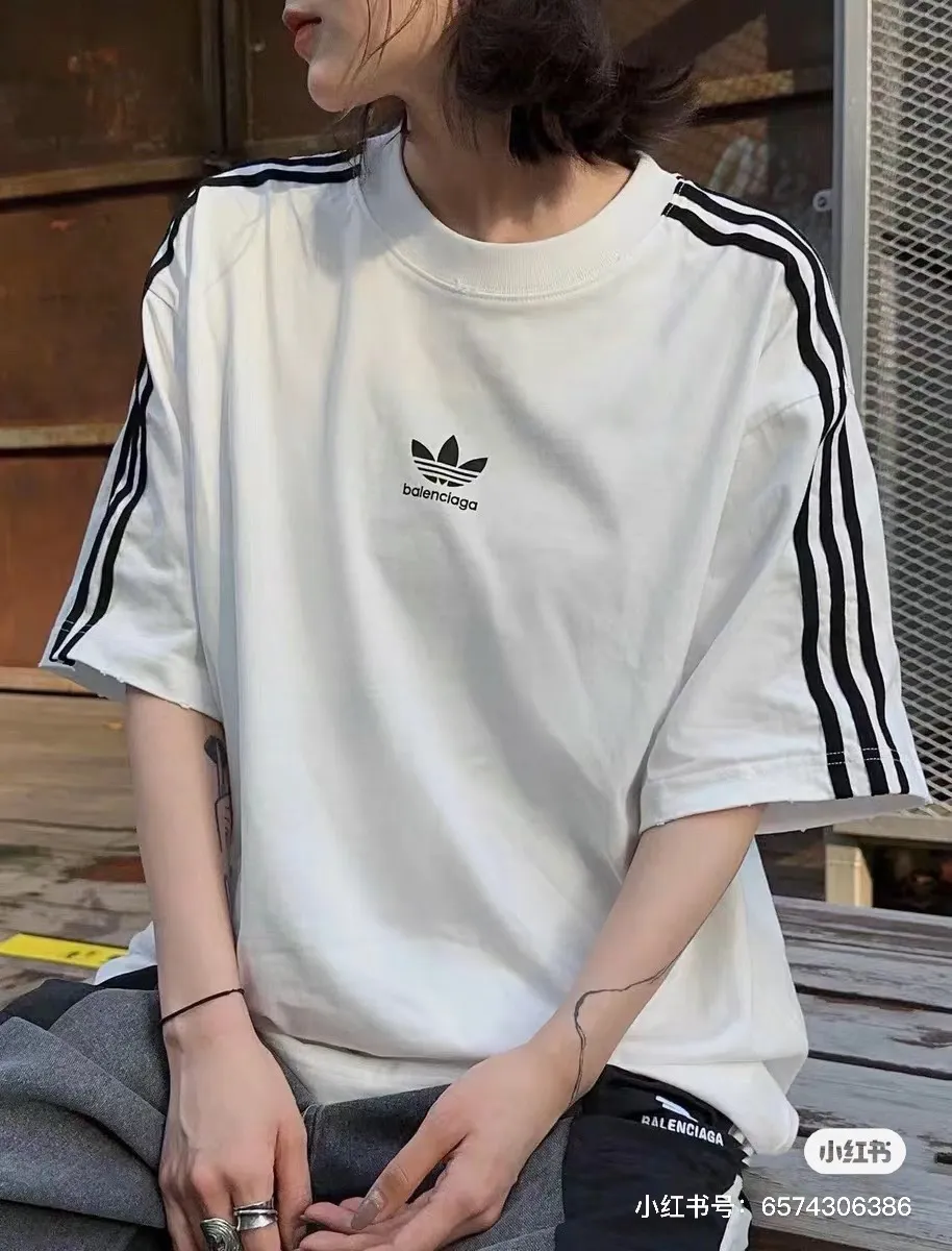 ♻️💯Upper body reference model picture❤️Top tested version - BALENCIAGA - Balenciaga co-branded Adidas Adidas clover striped LOGO offset printed short-sleeved T-shirt. The quality of No.1 in this market Real ceiling quality ✅All original development drawings pay attention to details to avoid mixed sales of stolen pictures ✅Correct 260g custom-woven and dyed double-yarn pure cotton fabric No color difference in custom-dyed threads ✅Correct imported material printing Conley machine white ink direct injection process The letters are clear and three-dimensional, firm and do not fall off ✅Overweight craftsmanship The original version is consistent Differential market currency Here I will explain why I am a little more expensive than others, 1. It seems to be a simple printing or embroidery, but it is not simple at all. 10000% imported machine restoration is not just a lip service. You are welcome to compare with peers. 2. Each model is produced by the company. The details of workmanship and fabrics are consistent with the original ones. It is guaranteed that there will be no color difference with the counters. Reproduction is not scary. Whoever is fake will be embarrassed. It’s not shameful to make a replica, it’s shameful if you can’t buy the correct version if you make a replica. 3. Note that the threaded collars are all original collars of certain countries and regions, with high wrapping. The width of the neckline and cabinets are accurate to the millimeter. Thick necklines are not easy to deform. The collars of high-end products are all restored cabinets. They are different from the big collars in the world. Ordinary garbage short-sleeves are printed with a print. The clavicle of the upper body is exposed. Please be patient. Customers who have bought genuine products or have seen genuine products will come back to place orders again. This is quality. This is quality. 4. Different styles of washed wheat main wheat, including imported wheat, have different colors and codes. Really restore the counter. As we all know, Balenciaga has different English or different colors on the collar labels of each quarter. This distinguishes the fast food products with the same common main wheat washed wheat. 5. Pay attention to the workmanship. The stitching at the neckline has no folds, smooth and natural without overlapping lines, and truly restores this. This is something that many people cannot do. 6. The fabric is made of 260g Paris-specific double yarn. No one can make better fabrics than my family. There's really no way to compare it with the ordinary version on the market. Respect it. It's genuine and costs thousands of dollars anyway. Don't buy street stalls. Quality 7. The workmanship is fully restored. The packaging is fully restored. The cost is huge. 8. I guarantee here that this is the highest quality you can find. Color: white black Size: XS to L P: 290