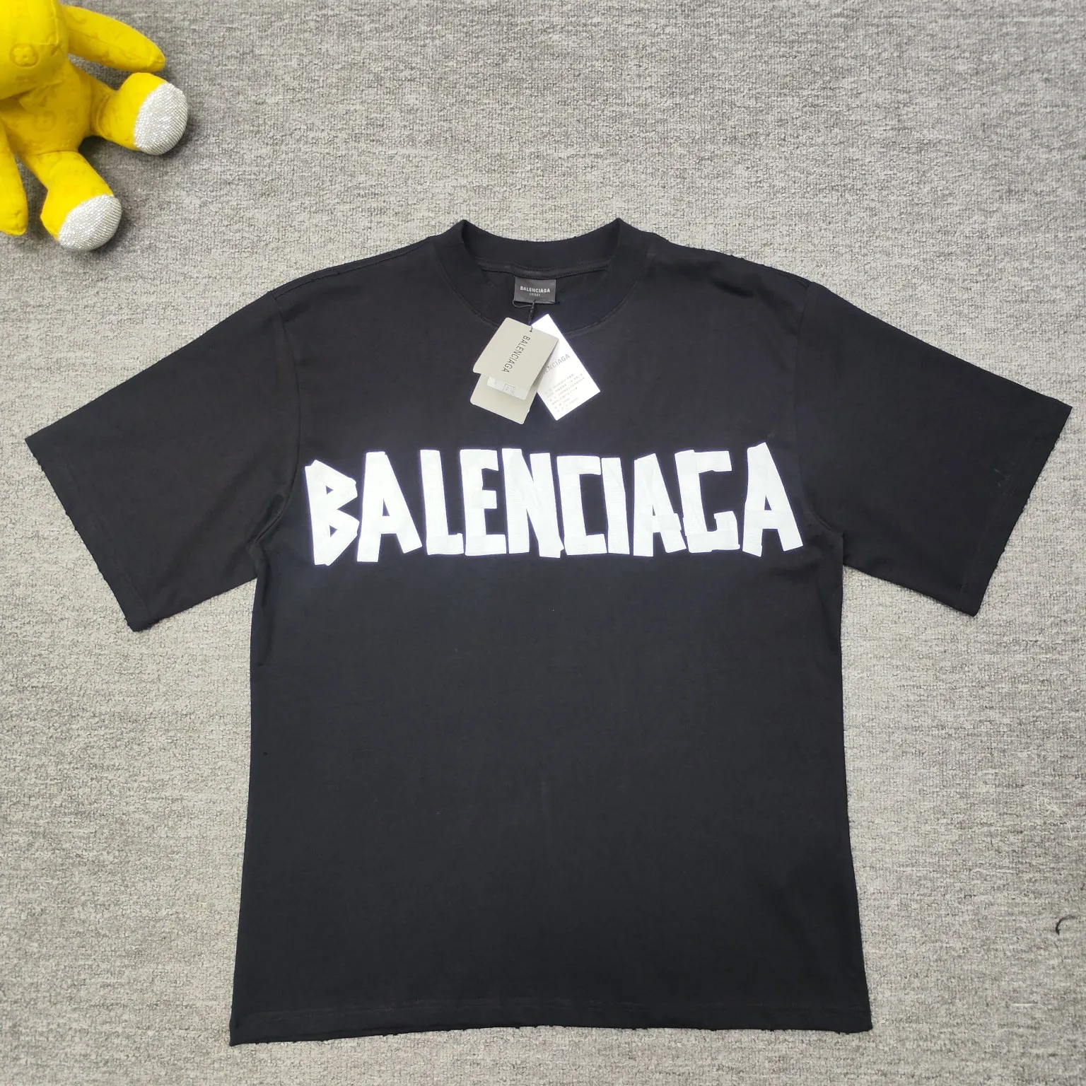 [New] Top version - BALENCIAGA - Masking tape short-sleeved T-shirt. The original developed custom-woven fabric process is washed and treated. The high-gram weight 300-gram fabric is full of texture. The cloth surface is clean, soft and comfortable. Solona thread custom dyeing has no color difference. The fabric is made of 16s single yarn combed cotton plain weave. The original is custom-dyed in gray and black, and the front panel is printed using an elliptical machine screen + digital direct inkjet integrated machine. Imported environmentally friendly glue + transparent slurry is used as a base and the digital slurry is scraped twice. The color is printed using digital direct inkjet printing. According to the original refined artwork, the color is deepened at the connection position of the letters. The overall visual effect is like a hand-made decal on textured paper. The back panel is printed with fluorescent ink, and all the blurred strokes are hand-painted at the connection positions of the letters, making the letters more three-dimensional in the overall visual effect. The garments are hand-worn and cut with holes, and softeners are added, sand-washed, fried, and made old and soft. os dropped shoulders, loose version, same style for men and women. Color: Reactive white, black, Size: XS-L P:280