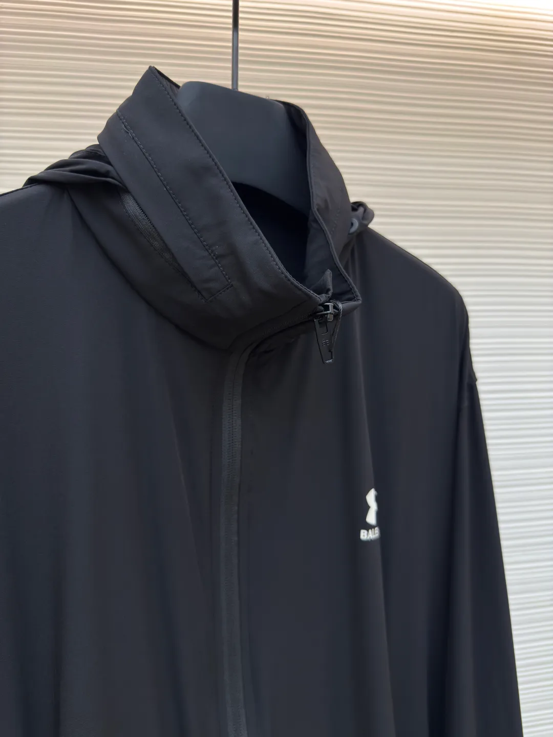 Balenciaga Paris co-branded stretch nylon jacket ●Authentic product: Purchased and developed by 4941 ●Item number: 1680072-B50 ●Fabric: stretch nylon fabric ●Technology: Made on positioning cutting machine ●Version: Loose version ●Weight: about 365 grams ●Size: 46-48-50-52 ●Description: The fabric is made of stretch nylon. Due to the addition of elastic fibers, it has excellent ductility and resilience, which can adapt to physical activities and provide a comfortable wearing experience. Nylon has natural waterproof properties, is easy to clean and dry, and has good anti-wrinkle properties. The front of the jacket is decorated with Under Armor LOGO and B family letters as the main glue printing, which has good wear resistance and washability. The back is also decorated with an enlarged version of the dual brand LOGO and letters. Highlighting the sense of fashion and brand recognition, the printed finished product is comparable to a work of art. A hidden bag is designed under the back collar, which can be opened and closed by a zipper. Due to the light and thin nature of the fabric, the hood can be hidden or opened according to different needs. There is a round beef tendon hat rope with a resin rope head at the neckline for easy adjustment of tightness. The overall wiring is straight and delicate, the fabric is comfortable and soft, and the color is consistent without color difference. It can be matched with the same style to create a fashionable look and control various occasions. Customized accessories, complete with three standards, same style for men and women!
