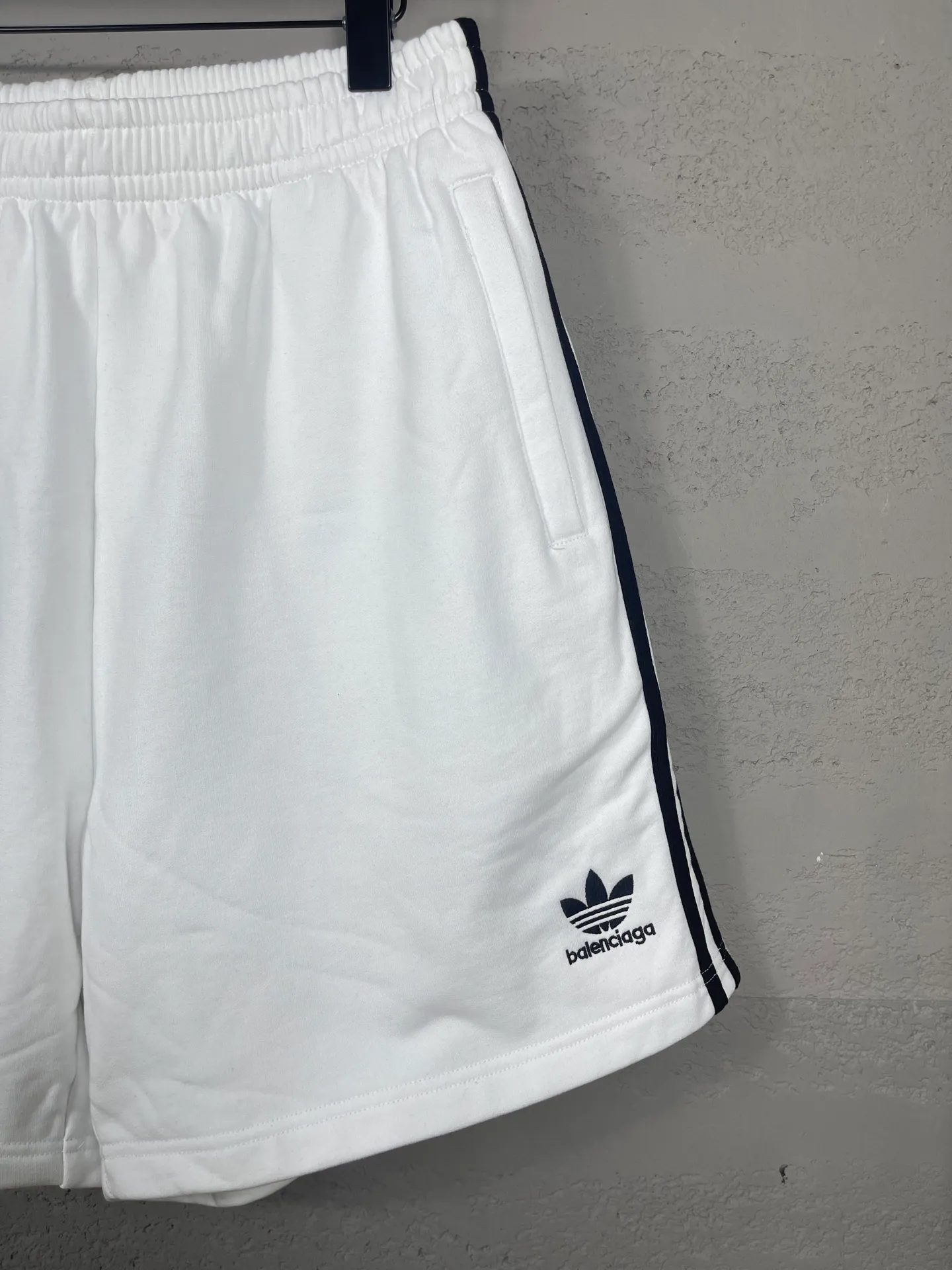 🅿️240 real shots [Top version. Official website quality] BALENCI*GA/Paris. 2025 new model. Paris co-branded adidas clover embroidered side seams. Invisible zipper shorts at the pocket. Brick cabinet synchronization. Genuine product developed at the first time, please print and compare! The fabric is made of Paris ZP custom-woven and dyed 100% cotton terry sweatshirt. The weight is 460 grams. The cloth surface is clean. The cloth pattern is clear and the hand feels soft and comfortable. The embroidery uses an imported Tajima embroidery machine. The letters are clear and the effect is three-dimensional. The version adopts a loose version. Same style for men and women. Code: BL257029 Color: black, white Size: XS S M L