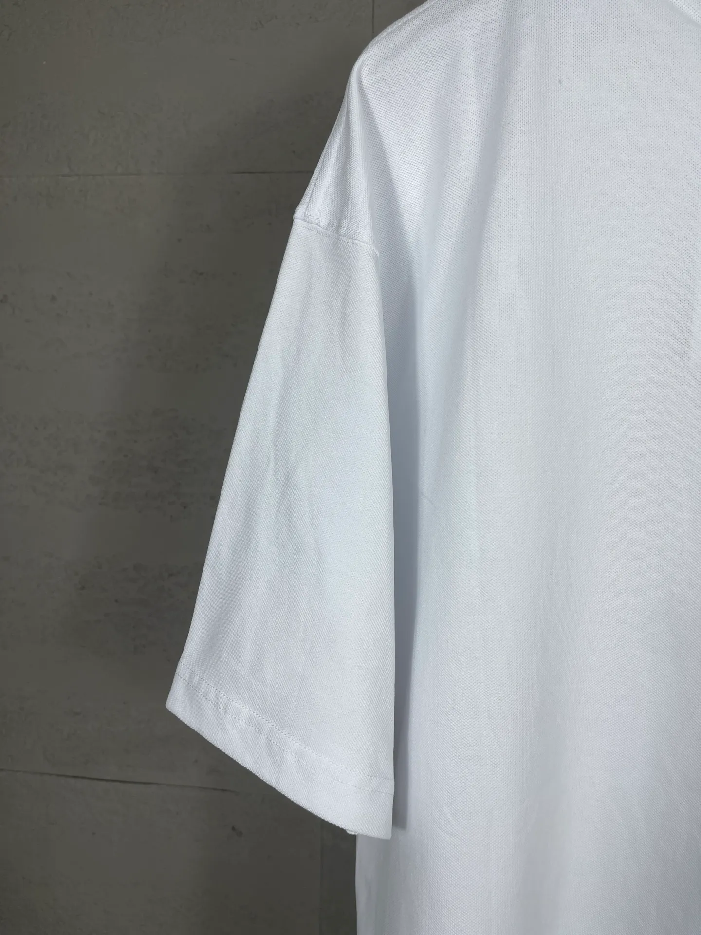 🅿️220 photos [Top version. Official website quality] BALENCI*GA/Paris #2025 new Paris letter LOGO embroidered POLO shirt, full of design, welcome to compare. The fabric is made of Paris ZP custom-woven and dyed cotton pique, with a weight of 260 grams. The cloth surface is clean. The cloth pattern is clear, soft and comfortable. The threads are woven and dyed with no color difference. The embroidered LOGO is embroidered using imported Tajima embroidery machine. The effect is three-dimensional. Restore the brick cabinet, adopt OS loose shoulder style. Same style for men and women. Coding: BL252218 Color: black, white Size: XS S M L