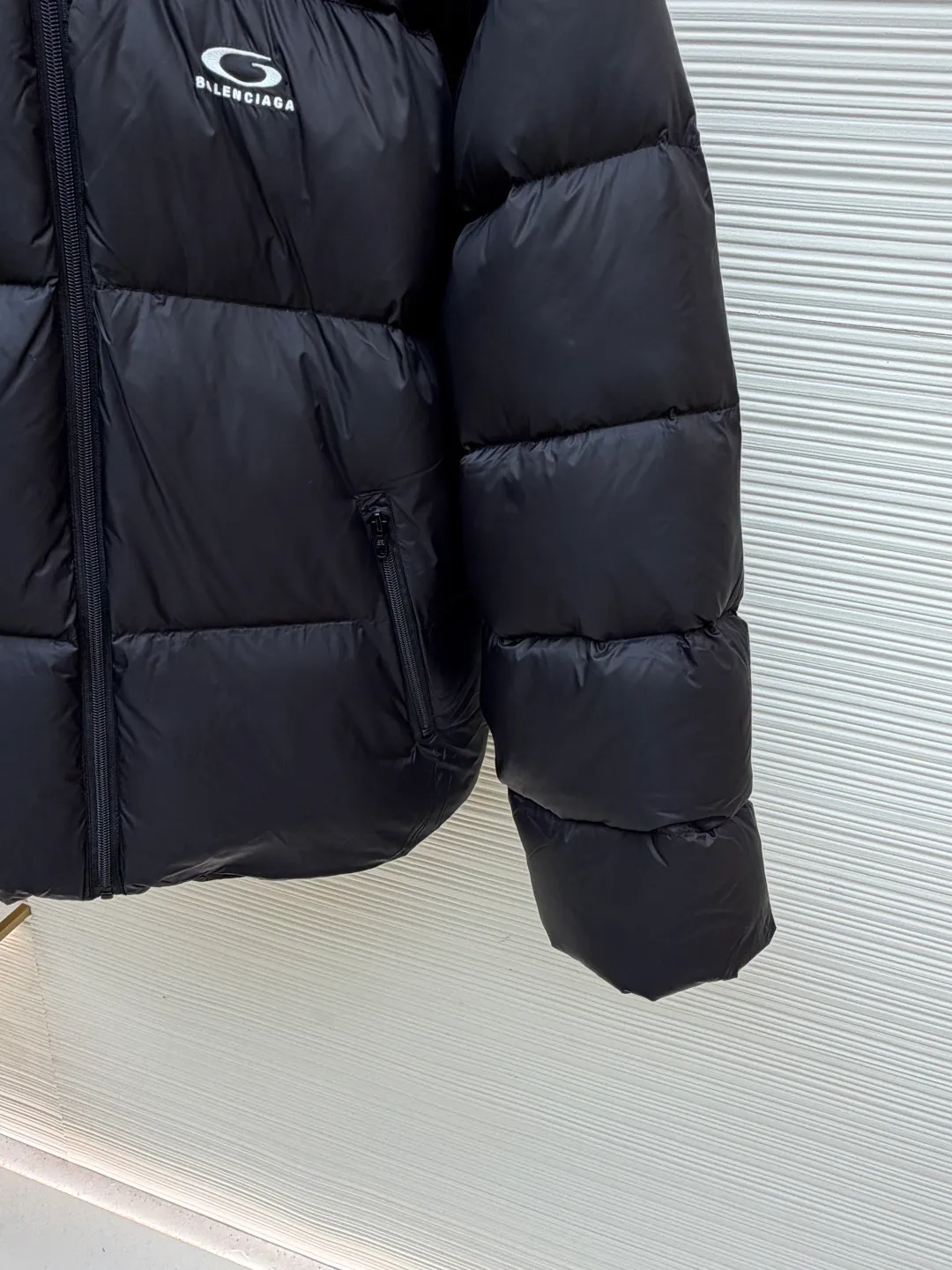 Balenciaga single-loop embroidered down jacket ●Original version: purchased and developed for 13899 ●Item number: 1681276-D15 ●Fabric: white duck down fabric ●Technology: mechanical down filling ●Color: black ●Version: loose version ●Weight: about 720 grams ●Size: S-M-L-XL ●Description: Custom-developed high-count and high-density woven fabric is the cornerstone of its high-end texture. High count means that the yarns are extremely fine, resulting in a finely textured and silky-touch surface; high density gives the fabric excellent stiffness, abrasion resistance and wind resistance. It avoids the rough feeling of ordinary cotton canvas and presents a low-key and precise micro-gloss, which provides a perfect and stable foundation for subsequent embroidery and hemming processes. The filling process needs to ensure that the cotton body is evenly distributed within the quilting grid without holes or agglomerations, which requires extremely high filling accuracy. The hemming is like the steel frame of a building, which strengthens the overall silhouette of the vest and makes the lines sharper and clearer, reflecting the brand's meticulous attitude towards tailoring. Dense embroidery on this thin and dense fabric can easily cause the fabric to shrink and deform. The brand will use special water-soluble lining or hot-melt lining on the bottom layer of embroidery. These linings will disappear after the embroidery is completed, ensuring that the pattern is smooth and crisp without destroying the flexibility of the fabric itself. This is the ultimate test of the combination of handicrafts and technology. The overall wiring is straight and delicate, the fabric is comfortable and soft, and the color is consistent without color difference. It can be matched with the same style to create a fashionable look and control various occasions. Customized accessories, complete with three standards, same style for men and women!