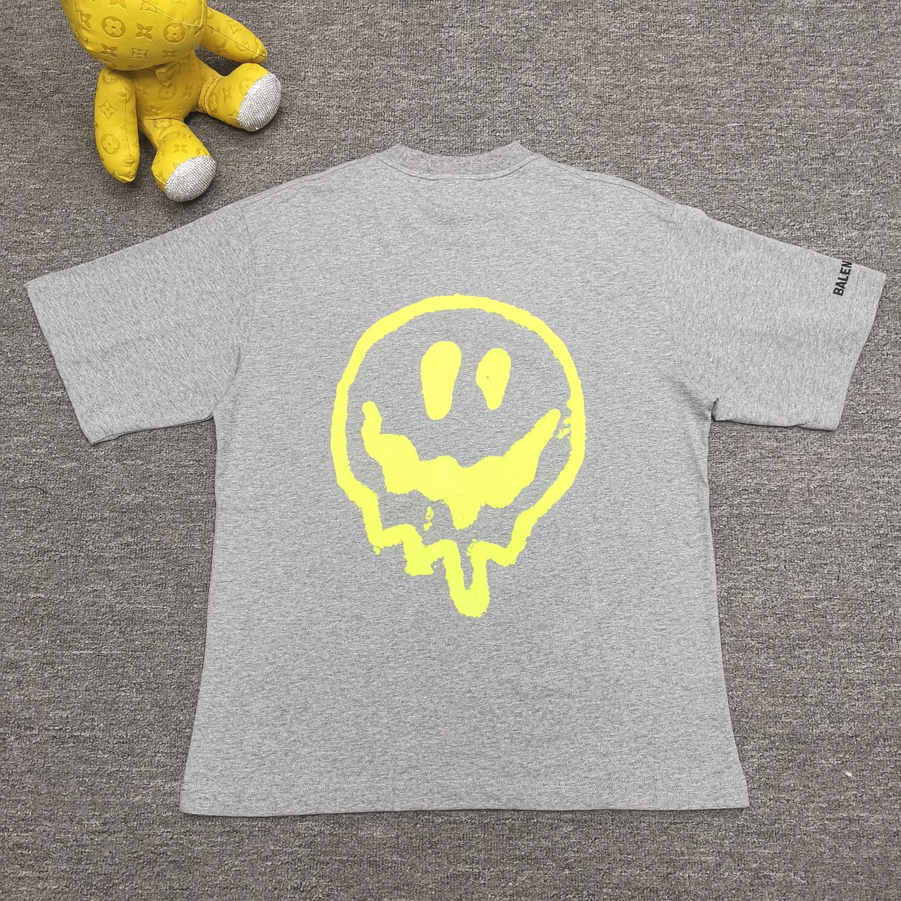 [Top version. Official website quality] BALENCI*GA/25 new style. The front is directly printed with hithg there + dripley art work + luminous effect, aliens are printed on the front, smiley faces are printed on the back, short-sleeved T-shirt with embroidered letters on the right sleeve # SS25 latest style. Research and development at the first time, different market currencies. Comparisons welcome. The fabric is made of Paris ZP custom-woven and dyed cotton double yarn. Weighing 260 grams, the cloth surface is clean. The cloth pattern is clear, soft and comfortable. The threads are dyed with no color difference. Printing adopts computer direct printing. Jubie market currency. Welcome to compare. The version adopts OS loose shoulder design. Same style for men and women. Color: off-white, black, floral gray. Size: XS S M L P260