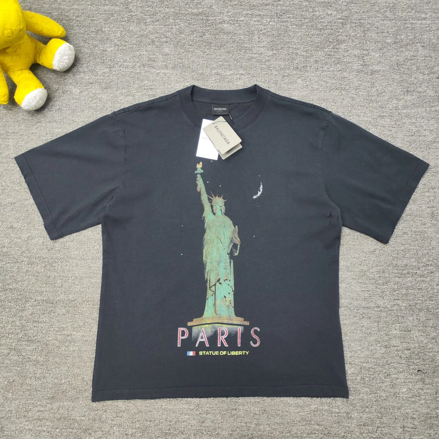 [New] Top version - BALENCIAGA - Statue of Liberty printed short-sleeved T-shirt. The original development of custom-woven fabric technology and washing treatment. High-gram weight 300-gram fabric, full texture, clean cloth surface, soft and comfortable. Solona thread dyeing has no color difference. The fabric uses a plain weave structure made of thicker yarns and has a retro style. Plain weave is a basic fabric structure characterized by frequent interweaving of warp and weft yarns. The fabric has a smooth appearance, clear texture, and a relatively light feel. Ready-to-wear garments are generally washable and comfortable to wear. The front is decorated with the Statue of Liberty. Printing process The Statue of Liberty National Monument, also known as Liberty Enlightening the World, is located on Liberty Island, New York, USA. On the occasion of the 100th anniversary of the founding of the United States, France presented a statue representing freedom. The underside of the statue is transformed into a Paris letter print, which is very symbolic. The design language of Balenciaga has a profound meaning. Graffiti prints are handsome and full of style. Washed and worn hole crafts os drop shoulders and loose version. Same style for men and women. Color: active white black. Size: XS-L P:300