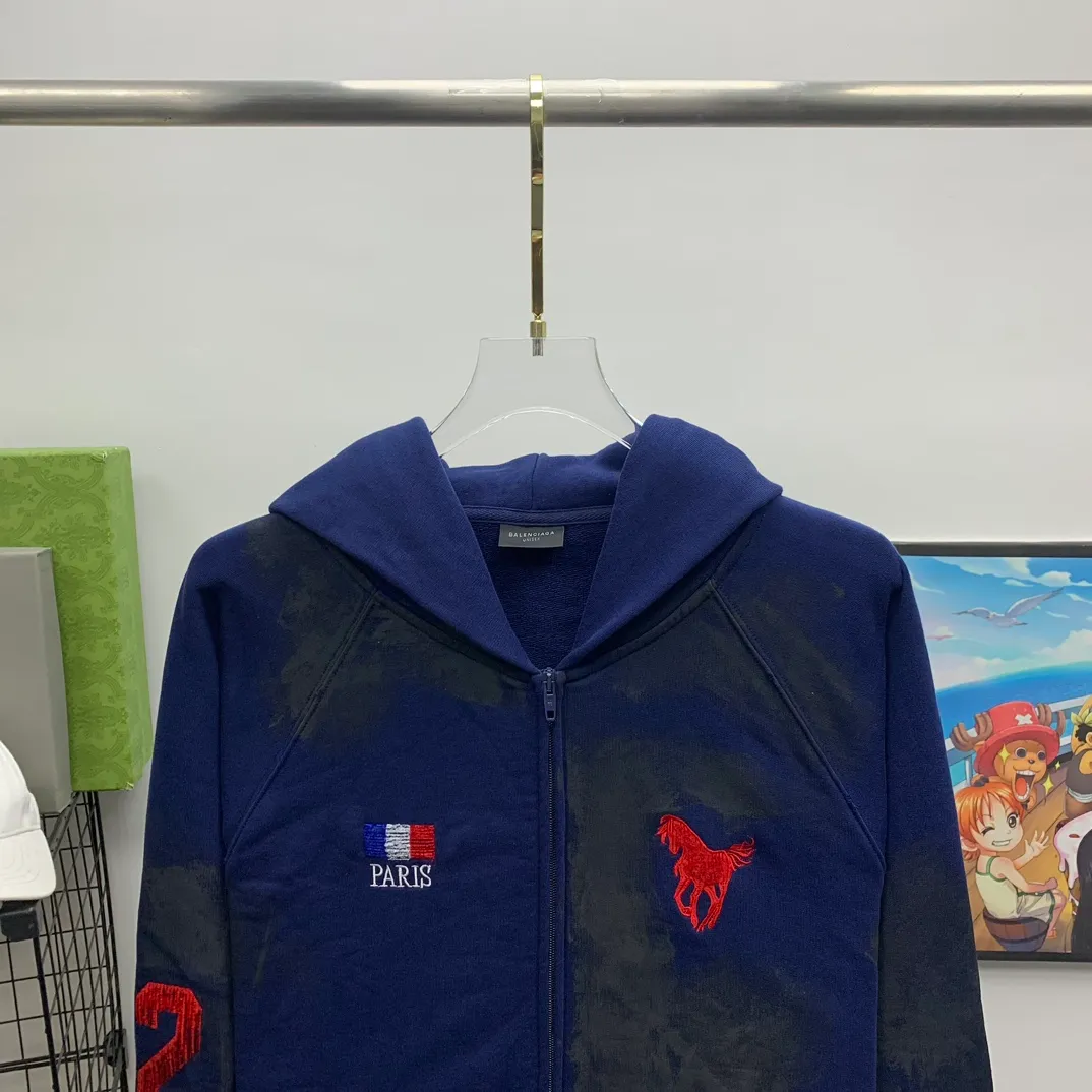 Top tested version Balenciaga Paris co-branded Lauren Raff mustang war horse embroidered flag muddy old dirty zipper cardigan sweatshirt #custom-woven Paris fabric 480g. The zipper is matched with a custom logo. Imported Tajima machines are used to embroider large-area heavy-duty high-density embroidery effects to make the embroidery more three-dimensional. The back is printed with imported glue. The ready-made garments are hand-ground and irregularly applied with mud to create a mud effect. Each piece of clothing needs to be coated three times, with an hour's interval between each coat to allow the coating to dry completely to ensure that the printing will not stick together. Exclusive and high quality due to heavy work and time consuming labor.   Color: Dark Blue Size: XS-L P:510
