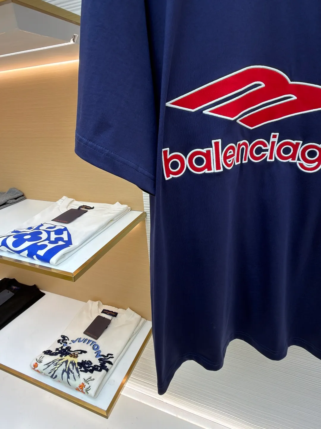 Balenciaga team series V-neck short sleeves ●Original version: Purchased and developed for 5699 ●Item number: 1682041-A50 ●Fabric: plain knitted compact cotton fabric ●Technology: glue printing ●Color: blue ●Version: loose version ●Weight: about 300 grams ●Size: Compact spinning technology is applied in the spinning process, which significantly reduces yarn hairiness and makes the yarn smoother and stronger. This gives the fabric an unusually dense structure, a smooth and smooth surface, and excellent pilling resistance, while retaining the softness and breathability of pure cotton. The weight of 185g is light to middleweight, ensuring that the clothing is light, drapeable and can move freely. It is very suitable for creating a long-sleeved shirt that combines sportiness with daily comfort. The V-neck part is made of two different colors of high-elastic rib fabrics. The process step is to first weave ribbed belts of two colors separately, and then through precise cutting and splicing, form a V-shaped neckline with sharp color contrast. It breaks the monotony of the solid color body, uses strong color contrast to create a young and energetic visual focus, and optimizes the neck line. The pattern is pre-cut and formed into patches on fabrics of different materials or colors, and then covered on the body. Finally, high-density embroidery thread is used to fix the edges and outline the internal details. Its function is to create patterns with bright colors, strong texture contrast, three-dimensionality and durability. The edges of the pattern are strong and not easy to wear. A special elastic paste is screen-printed on the sleeves to create brightly colored patterns with a slightly coated feel. The elastic paste ensures that the printed area can stretch with the fabric without cracking. It forms a texture contrast between one flat and one convex with the three-dimensional sense of appliqué, which increases the interest and complexity of the design. The overall wiring is straight and delicate, the fabric is comfortable and soft, and the color is consistent without color difference. It can be matched with the same style to create a fashionable look and control various occasions. Customized accessories, complete with three standards, same style for men and women!
