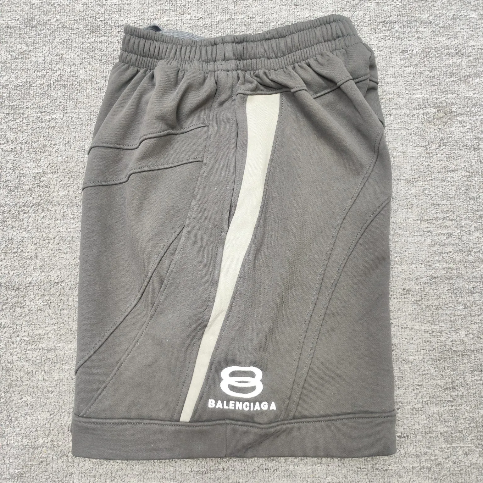 The top version of Balenciaga's new BLCG 24SS new heavy industry motorcycle style double ring embroidered splicing shorts, heavy industry motorcycle style design. The fabric is made of high-density sweatshirt fabric and weighs 400 grams after washing. It feels delicate and soft and has singeing and dust removal technology. The double-ring letter pattern is embroidered with thousands of needles imported from Tajima machines, using precision needle embroidery technology. The embroidery is very fine and dense, the letter pattern outlines the design clearly, and the garment bone hemming technology is strict and fine in workmanship to ensure seamless connection. The garments are made from green fabrics that are printed and then fried. The fabrics are dyed through stone grinding. After frying, the fabrics are slightly whitened. The color of the original fabrics is changed to show a nostalgic color with different shades of light and dark. The three-dimensional silhouette is cut and the upper body is highly recognizable. Size: XS-L Color: Gray P:340