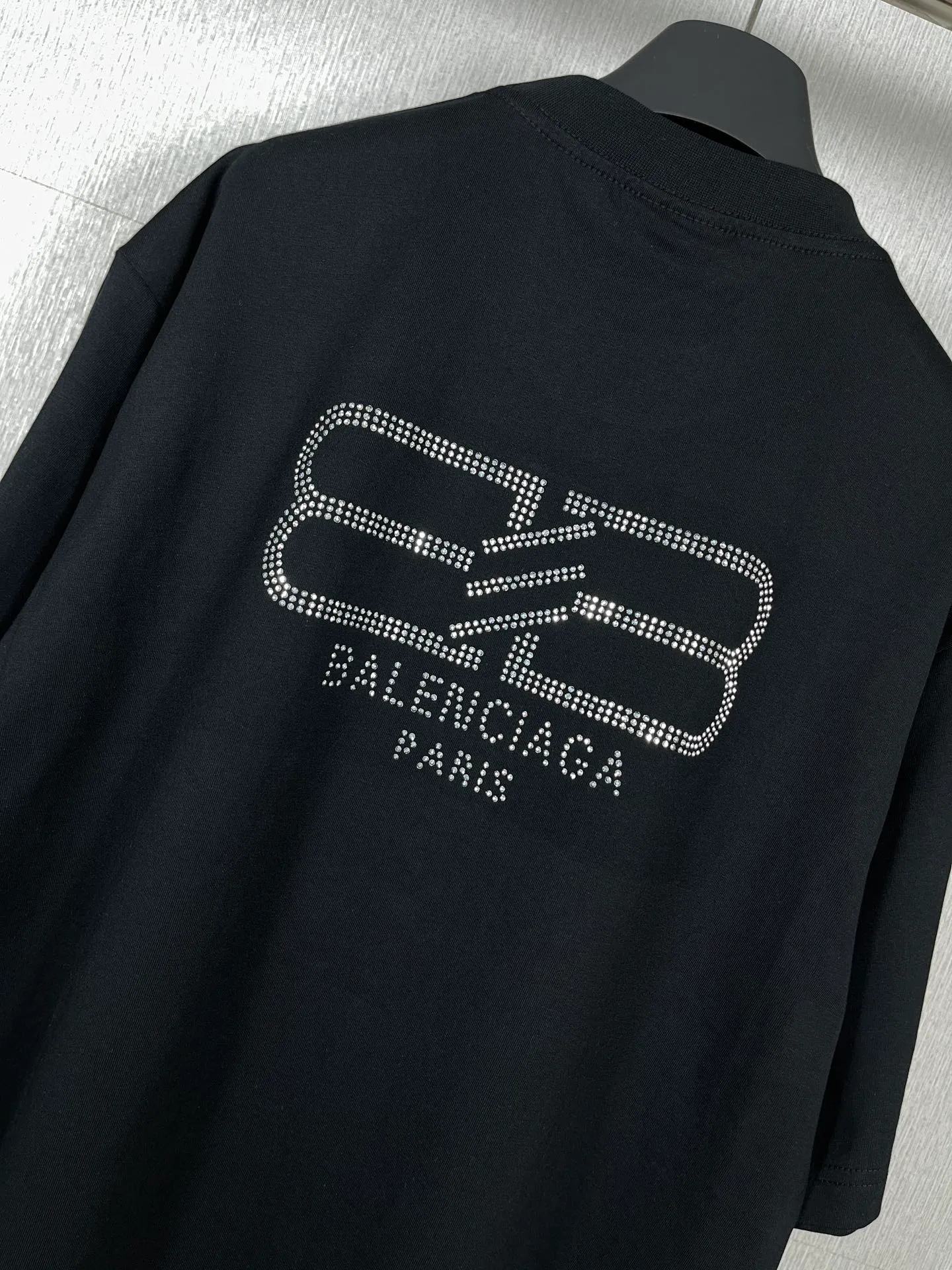 🅿️180 real photos [Top version. Official website quality] BALENCI*GA/Paris BALENCI*GA#23SS Paris classic lock button back classic LOGO hot-drilled short-sleeved T-shirt. Brick cabinet synchronization. The fabric is made of Paris ZP custom-woven and dyed 100% cotton double yarn compact cotton. The weight is 260 grams. The cloth surface is clean. The cloth pattern is clear. Soft and comfortable. Good color fastness. Not easy to change color. The threads are woven and dyed with no color difference. The back hot drill uses imported drill, which has good gloss and is not easy to fall off. Restore brick cabinet. The version adopts OS loose shoulder style. Same style for men and women. Code: BL223200 Color: Black. White Size: XS to L
