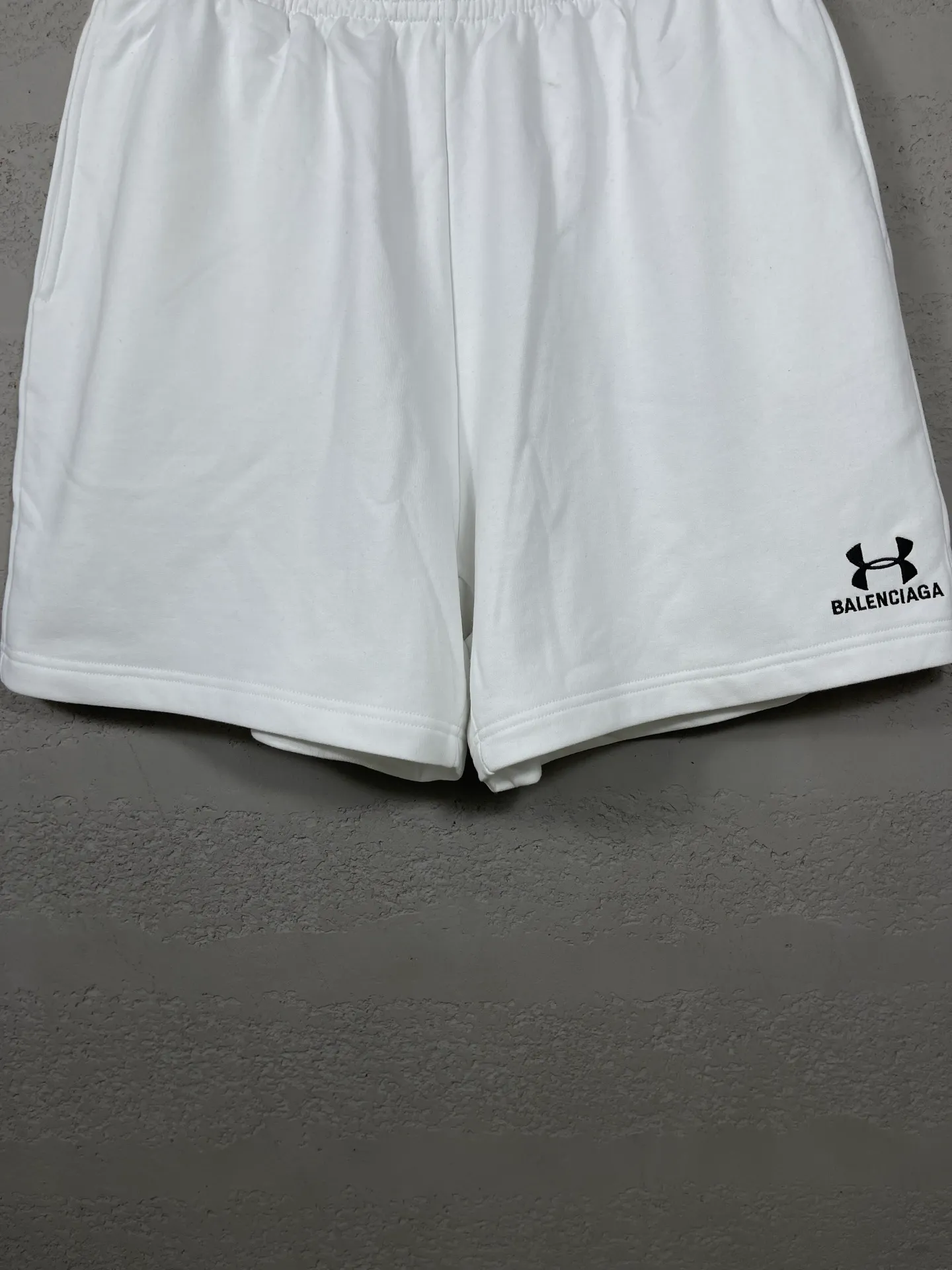 🅿️210 real photos [Top version. Official website quality] BALENCI*GA/Paris. 2025 new model. New embroidered shorts co-branded by Under Armor in Paris. Synchronized with brick cabinets. Developed as genuine products at the first time, please print and compare! The fabric is made of Paris ZP custom-woven and dyed 100% cotton terry sweatshirt. The weight is 460 grams. The cloth surface is clean. The cloth pattern is clear and the hand feels soft and comfortable. The embroidery uses an imported Tajima embroidery machine. The letters are clear and the effect is three-dimensional. The version adopts a loose version. Same style for men and women. Code: BL257003 Color: black, white Size: XS S M L