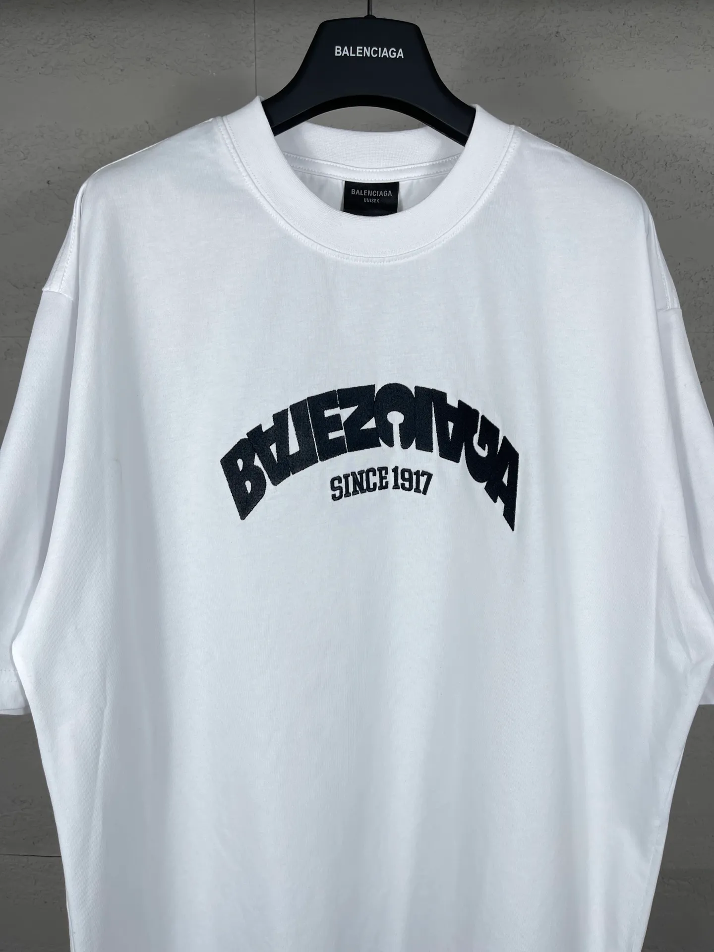 🅿️180 real photos [Top version. Official website quality] BALENCI*GA/Paris BALENCI*GA#2024 latest model, large reverse letter LOGO icon embroidered short-sleeved T-shirt. Brick cabinet synchronization. Genuine products are developed and developed in the first time. Welcome to compare! The fabric is made of Paris ZP custom-woven and dyed 100% cotton double-yarn compact cotton. The weight is 260 grams. The cloth surface is clean. The cloth pattern is clear. It is soft and comfortable. It has good color fastness and is not easy to change color. The threads are woven and dyed with no color difference. The embroidery is done using an imported Tajima embroidery machine, with a three-dimensional effect and clear lines. There are no burrs and miscellaneous threads, and the embroidery is of ultra-high craftsmanship. The version adopts OS loose shoulder design. Same style for men and women. Code: BL223215 Color: Black. White Size: XS to L