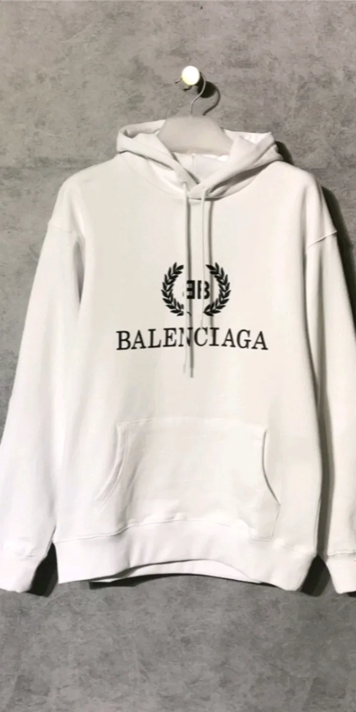 Real shot of the video - the top tested version of Balenciaga's classic wheat ear hooded sweatshirt. It is made of 480g pure cotton double-yarn terry fabric, which is thick and textured. It is made of high-density knitted fabric technology. It is firm and elastic, with high suppleness and skin-friendliness. It feels soft and delicate, does not shrink or deform, and has a crisp and stylish upper body. It is different from the cheap soft sofa fabrics with low weight and low count on the market.  Ultra-high-level workmanship, every detail shows a sense of luxury, and the original three-dimensional cutting process creates a perfect fit. The OS loose shoulder style accommodates all body types. It is a truly versatile style that looks slim and good-looking for both men and women.  The brushed classic wheat ear letter print has high fastness and will not crack or fall off. The classic pattern will never go out of style. Multiple colors are available, and every color is beautiful!  Color: White Size: XS-L P:420