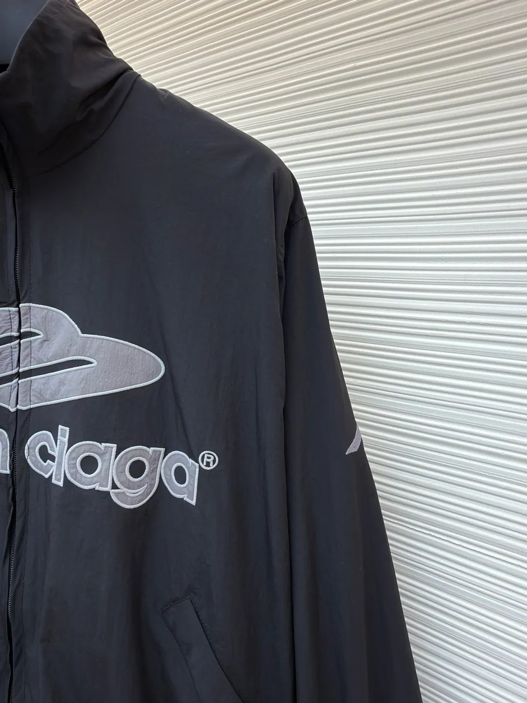 Balenciaga letter logo printed long-sleeved stand-collar jacket ●Original version: purchased and developed by 18499 ●Item number: 1682141-B45 ●Fabric: technical quick-drying fabric ●Technology: printing production ●Color: black ●Version: loose fit ●Weight: about 465 grams ●Size: XS-S-M-L ●Description: This Balenciaga black jacket is made of high-density nylon taffeta fabric. The fabric is first treated with water-repellent treatment, and a nano-scale waterproof membrane is formed on the surface. It is both windproof and lightweight. It is also pre-shrunk, making the garment less likely to shrink and deform. The brand logo and pattern on the body of the garment are 3D silicone hot stamping process. It is made of environmentally friendly silicone material with high elasticity and folding resistance. It is formed by hot pressing at 180°C high temperature and high pressure. The pattern and fabric are firmly combined, not easy to fall off and have a three-dimensional matte texture. The woven label on the side adopts computerized jacquard woven label technology, with a color fastness of above level 4, and the edges are heat-sealed to prevent stripping. The zipper is a custom-made metal matte zipper with wear-resistant electroplating treatment on the teeth. The ribbed edges of the collar and hem have built-in spandex elastic yarn. The splicing of the body is made of overlock seams. The stitches are evenly spaced and the seams are flat. The entire body is ironed and shaped by hand to perfectly present the brand's iconic oversize loose fit. The overall wiring is straight and delicate, the fabric is comfortable and soft, and the color is consistent without color difference. It can be matched with the same style to create a fashionable look and control various occasions. Customized accessories, complete with three standards, same style for men and women!