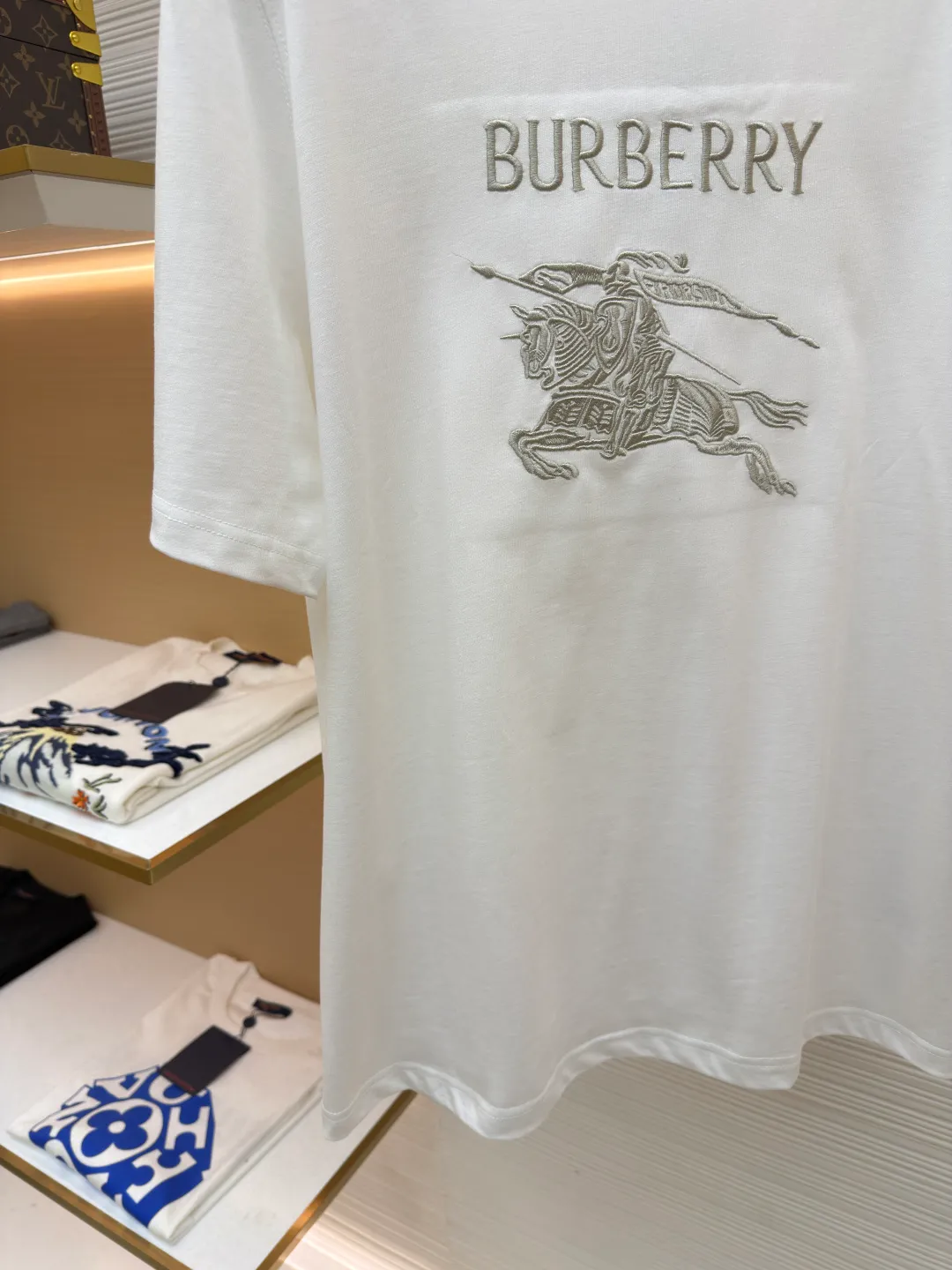 Burberry Thin Line War Horse Embroidery Round Neck Short Sleeve ●Original version: 3250 purchase and development ●Item number: 1681453-X90 ●Fabric: pure cotton fabric ●Technology: embroidery production ●Color: white ●Version: fitted version ●Weight: about 300 grams ●Size: S-M-L-XL ●Description: This T-shirt is made of high-quality pure cotton fabric, which is skin-friendly and breathable. Black and off-white tones are classic and versatile. The brand knight logo on the front adopts precision embroidery technology. The silk thread is rich in color, the stitching is delicate and three-dimensional, and the pattern is rich in layers, highlighting the high brand recognition. The round neck structure is processed by overlocking technology, and the neckline fits the neck and is not easily deformed. The body of the garment is sewn using industrial-grade flat stitching technology. The stitches are smooth and even, and the stitches at the hem and cuffs are fine and firm. From the selection of pure cotton fabrics to the control of embroidery details, every process reflects Burberry's pursuit of craft precision and classic style. It not only retains the daily practicality of the T-shirt, but also demonstrates the brand's light luxury recognition through exquisite embroidery. It is a fusion of casual style and exquisite craftsmanship. The overall wiring is straight and delicate, the fabric is comfortable and soft, and the color is consistent without color difference. It can be matched with the same style to create a fashionable look and control various occasions. Customized accessories, complete with three standards, same style for men and women!