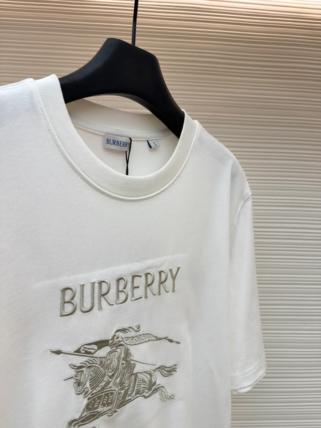 Burberry Thin Line War Horse Embroidery Round Neck Short Sleeve ●Original version: 3250 purchase and development ●Item number: 1681453-X90 ●Fabric: pure cotton fabric ●Technology: embroidery production ●Color: white ●Version: fitted version ●Weight: about 300 grams ●Size: S-M-L-XL ●Description: This T-shirt is made of high-quality pure cotton fabric, which is skin-friendly and breathable. Black and off-white tones are classic and versatile. The brand knight logo on the front adopts precision embroidery technology. The silk thread is rich in color, the stitching is delicate and three-dimensional, and the pattern is rich in layers, highlighting the high brand recognition. The round neck structure is processed by overlocking technology, and the neckline fits the neck and is not easily deformed. The body of the garment is sewn using industrial-grade flat stitching technology. The stitches are smooth and even, and the stitches at the hem and cuffs are fine and firm. From the selection of pure cotton fabrics to the control of embroidery details, every process reflects Burberry's pursuit of craft precision and classic style. It not only retains the daily practicality of the T-shirt, but also demonstrates the brand's light luxury recognition through exquisite embroidery. It is a fusion of casual style and exquisite craftsmanship. The overall wiring is straight and delicate, the fabric is comfortable and soft, and the color is consistent without color difference. It can be matched with the same style to create a fashionable look and control various occasions. Customized accessories, complete with three standards, same style for men and women!