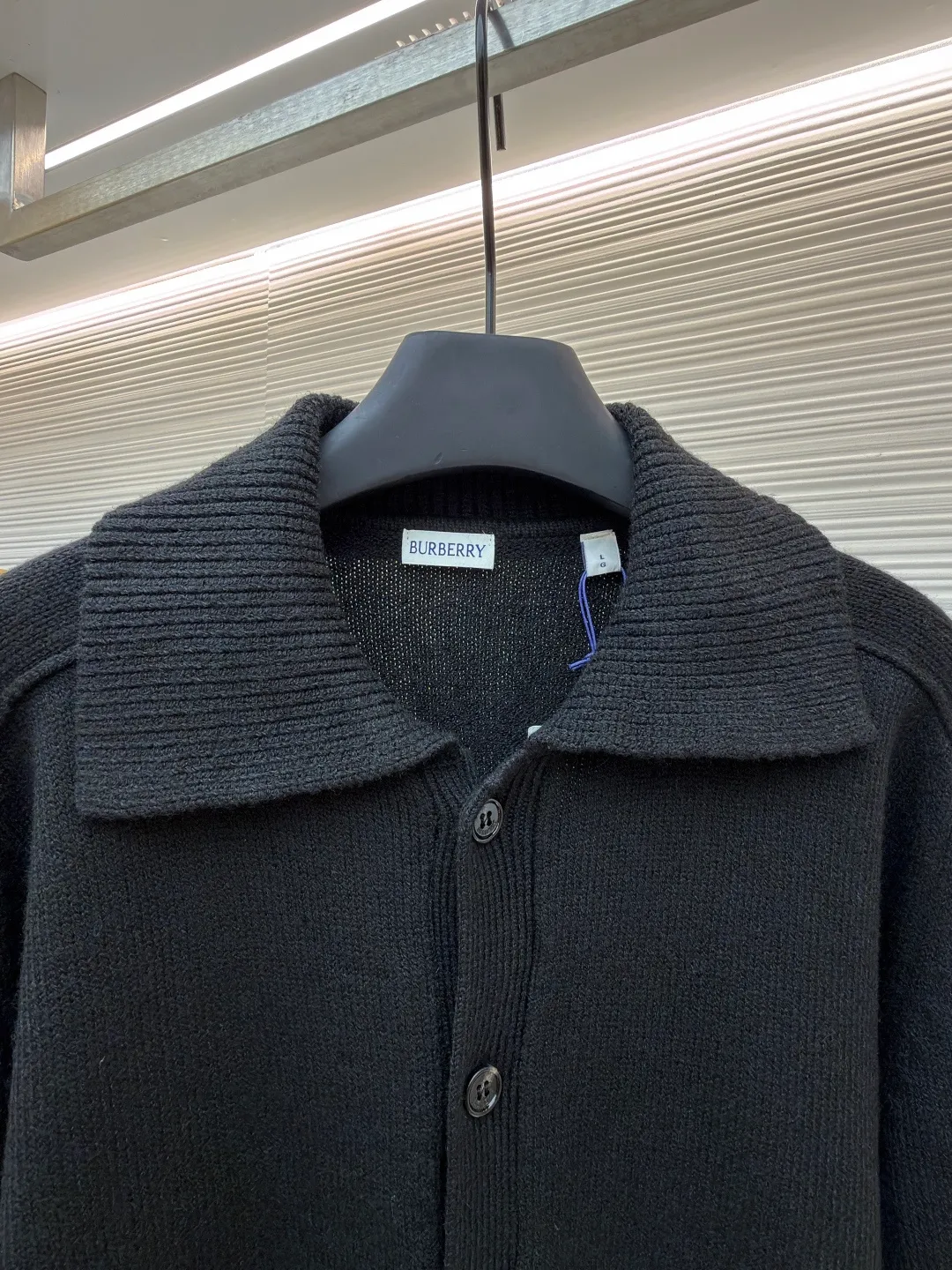 Burberry lapel rib knitted cashmere sweater ●Original version: purchased and developed by 11575 ●Item number: 1682226-B15 ●Fabric: wool blended fabric ●Technology: knitted ●Color: black ●Version: fitted version ●Weight: about 600 grams ●Size: S-M-L-XL ●Description: This black knitted cardigan is knitted with high-count worsted wool yarn. The main body is built using four-flat stitch technology, which gives the fabric good elasticity and shapeability, while forming a fine and tight texture. The ribbed lapel weaving process is used at the neckline, and a combination of different needle types is used to create a crisp collar profile. The rib structure can be freely expanded and contracted according to the wearing status to fit the neck line. The placket adopts inlaid buttonhole technology and is matched with matte resin buttons of the same color. The buttons and the body are fixed by hand-stitching, which is strong and beautiful. The brand logo patch on the lower side of the body is processed by a hot-pressing bonding process and fits seamlessly with the knitted fabric. The overall cut is a slightly loose shoulder-drop version, combined with three-dimensional darting technology, which ensures wearing comfort while creating clean lines. Every knitting node is manually inspected to ensure the uniformity and integrity of the knitted texture. The overall wiring is straight and delicate, the fabric is comfortable and soft, and the color is consistent without color difference. It can be matched with the same style to create a fashionable look and control various occasions. Customized accessories, complete with three standards, same style for men and women!