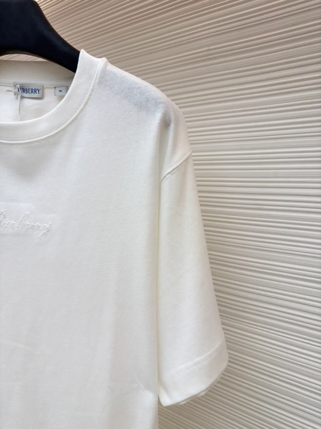 Burberry Plaid Back Letter Embroidery Round Neck Short Sleeve ●Original version: purchased and developed by 4984 ●Item number: 1681564-A10 ●Fabric: pure cotton fabric ●Technology: embroidery production ●Color: white ●Version: fitted version ●Weight: about 275 grams ●Size: XS-S-M-L ●Description: Made of 15S fine cotton plain weave, white/230g, black/310g; matching 32S double yarn tension frame thread, 300g. Made of pure cotton plain woven fabric, this weave has a tight structure, giving the fabric a crisp texture and excellent durability, while retaining the natural breathability and skin-friendly properties of cotton. The plain woven fabric is not easy to deform, avoids being too loose and casual, and provides a neater silhouette. The chest and back are embellished with letter logo embroidery, forming a visual rhythm that echoes the front and back, both presented through chain stitch embroidery technology. These logos also use high-precision embroidery technology to ensure clear edges, strong and durable. Unique embroidery technique, its stitches are interlocking like a chain, making it more three-dimensional, softer to the touch, and has a unique texture and luster. Presenting the classic plaid pattern with this process is an innovative deconstruction of the traditional elements of the brand. It transforms the original flat pattern into a three-dimensional texture with handicraft warmth, which greatly enhances the sophistication and value of the design. The overall wiring is straight and delicate, the fabric is comfortable and soft, and the color is consistent without color difference. It can be matched with the same style to create a fashionable look and control various occasions. Customized accessories, complete with three standards, same style for men and women!