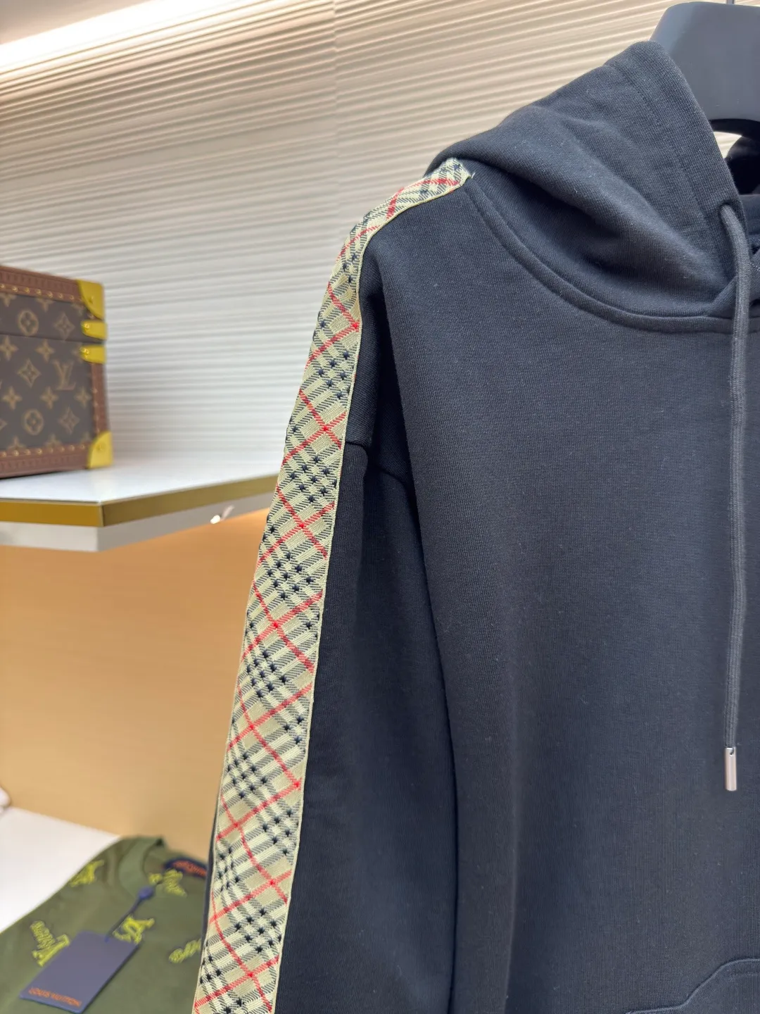 BURBERRY Ribbon trim hooded pullover sweatshirt ●Authentic product: Purchased and developed by 6239 ●Item number: 1680511-B15 ●Fabric: single-sided fish scale fabric ●Technology: selvedge production ●Version: fitted version ●Weight: about 895 grams ●Size: S-M-L-XL ●Description: A single-sided fish-scale cloth fabric woven with cotton as the base. The front is a smooth knitted surface, and the skin-contacting surface is formed into three-dimensional terry by the floating thread knitting technology of the knitting machine, which increases the fluffiness and has a delicate touch. The terry structure absorbs a large amount of water and evaporates quickly, so it is not easy to loosen and deform after repeated washing. By actively interfering with the shrinkage potential of cotton fibers, the fabric is able to transition from changeable to stable, improving dimensional stability while being less prone to deformation and wrinkles. The monochrome flat embroidery on the chest uses the high-precision calculation system of the computer embroidery machine to control the coordinated operation of the machine head, needle bar, and thread spool. The fabric frame moves accurately in the horizontal and vertical directions to form a stitch track. The upper and lower thread tensions are adjusted to ensure that the stitches are smooth and free of floating threads, forming a fine pattern with an error of ±0.1mm. The overall wiring is straight and delicate, the fabric is comfortable and soft, and the color is consistent without color difference. It can be matched with the same style to create a fashionable look and control various occasions. Customized accessories, complete with three standards, same style for men and women!