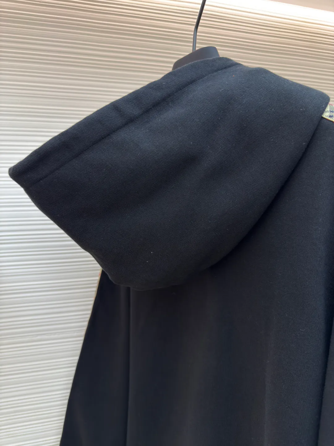 BURBERRY Ribbon trim hooded pullover sweatshirt ●Authentic product: Purchased and developed by 6239 ●Item number: 1680511-B15 ●Fabric: single-sided fish scale fabric ●Technology: selvedge production ●Version: fitted version ●Weight: about 895 grams ●Size: S-M-L-XL ●Description: A single-sided fish-scale cloth fabric woven with cotton as the base. The front is a smooth knitted surface, and the skin-contacting surface is formed into three-dimensional terry by the floating thread knitting technology of the knitting machine, which increases the fluffiness and has a delicate touch. The terry structure absorbs a large amount of water and evaporates quickly, so it is not easy to loosen and deform after repeated washing. By actively interfering with the shrinkage potential of cotton fibers, the fabric is able to transition from changeable to stable, improving dimensional stability while being less prone to deformation and wrinkles. The monochrome flat embroidery on the chest uses the high-precision calculation system of the computer embroidery machine to control the coordinated operation of the machine head, needle bar, and thread spool. The fabric frame moves accurately in the horizontal and vertical directions to form a stitch track. The upper and lower thread tensions are adjusted to ensure that the stitches are smooth and free of floating threads, forming a fine pattern with an error of ±0.1mm. The overall wiring is straight and delicate, the fabric is comfortable and soft, and the color is consistent without color difference. It can be matched with the same style to create a fashionable look and control various occasions. Customized accessories, complete with three standards, same style for men and women!