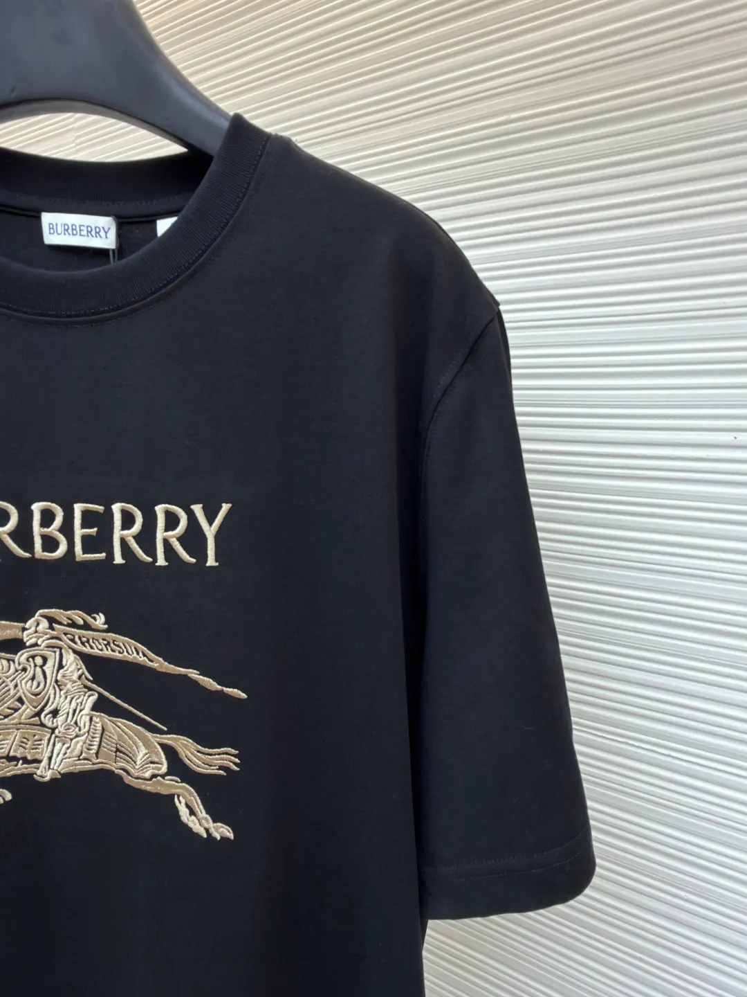 Burberry Thin Line War Horse Embroidery Round Neck Short Sleeve ●Original version: purchased and developed for 3250 ●Item number: 1681452-X90 ●Fabric: pure cotton fabric ●Technology: embroidery production ●Color: black ●Version: fitted version ●Weight: about 300 grams ●Size: S-M-L-XL ●Description: This T-shirt is made of high-quality pure cotton fabric, which is skin-friendly and breathable. The black and off-white tones are classic and versatile. The brand knight logo on the front adopts precision embroidery technology. The silk thread is rich in color, the stitching is delicate and three-dimensional, and the pattern is rich in layers, highlighting the high brand recognition. The round neck structure is processed by overlocking technology, and the neckline fits the neck and is not easily deformed. The body of the garment is sewn using industrial-grade flat stitching technology. The stitches are smooth and even, and the stitches at the hem and cuffs are fine and firm. From the selection of pure cotton fabrics to the control of embroidery details, every process reflects Burberry's pursuit of craft precision and classic style. It not only retains the daily practicality of the T-shirt, but also demonstrates the brand's light luxury recognition through exquisite embroidery. It is a fusion of casual style and exquisite craftsmanship. The overall wiring is straight and delicate, the fabric is comfortable and soft, and the color is consistent without color difference. It can be matched with the same style to create a fashionable look and control various occasions. Customized accessories, complete with three standards, same style for men and women!