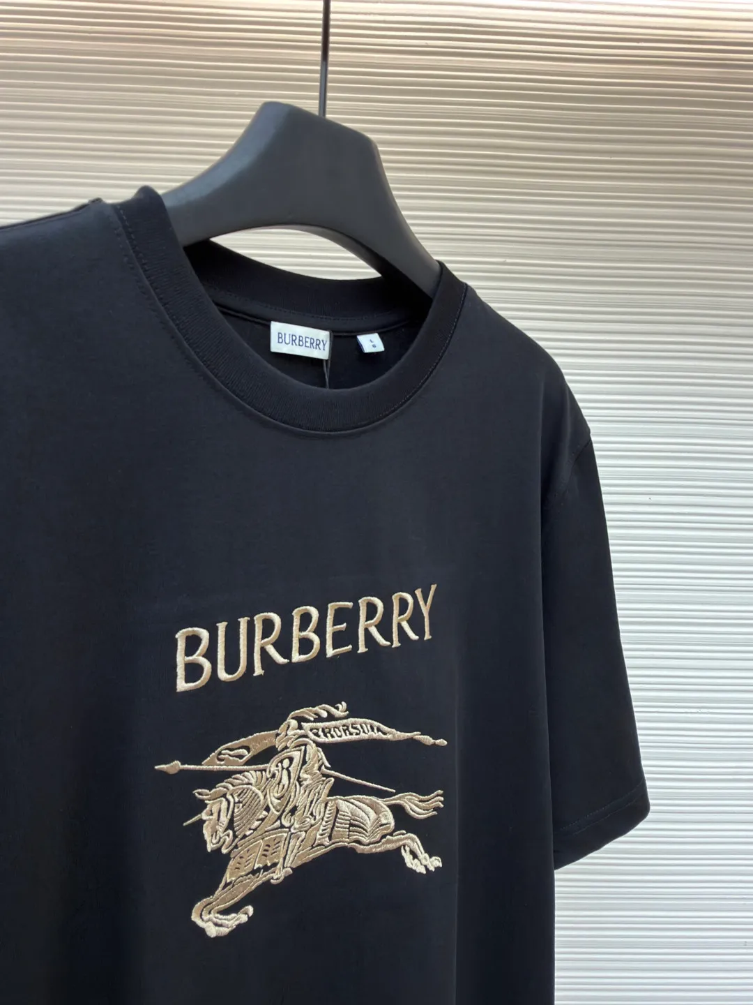 Burberry Thin Line War Horse Embroidery Round Neck Short Sleeve ●Original version: purchased and developed for 3250 ●Item number: 1681452-X90 ●Fabric: pure cotton fabric ●Technology: embroidery production ●Color: black ●Version: fitted version ●Weight: about 300 grams ●Size: S-M-L-XL ●Description: This T-shirt is made of high-quality pure cotton fabric, which is skin-friendly and breathable. The black and off-white tones are classic and versatile. The brand knight logo on the front adopts precision embroidery technology. The silk thread is rich in color, the stitching is delicate and three-dimensional, and the pattern is rich in layers, highlighting the high brand recognition. The round neck structure is processed by overlocking technology, and the neckline fits the neck and is not easily deformed. The body of the garment is sewn using industrial-grade flat stitching technology. The stitches are smooth and even, and the stitches at the hem and cuffs are fine and firm. From the selection of pure cotton fabrics to the control of embroidery details, every process reflects Burberry's pursuit of craft precision and classic style. It not only retains the daily practicality of the T-shirt, but also demonstrates the brand's light luxury recognition through exquisite embroidery. It is a fusion of casual style and exquisite craftsmanship. The overall wiring is straight and delicate, the fabric is comfortable and soft, and the color is consistent without color difference. It can be matched with the same style to create a fashionable look and control various occasions. Customized accessories, complete with three standards, same style for men and women!