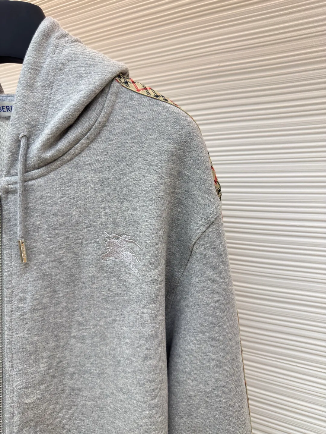 BURBERRY webbing trim embroidered hooded sweatshirt ●Authentic product: purchased and developed by 3610 ●Item number: 1680520-B50 ●Fabric: single-sided fish scale fabric ●Technology: selvedge production ●Version: fitted version ●Weight: about 920 grams ●Size: S-M-L-XL ●Description: Made of cotton as the main body, fed with 6% polyester fiber and 2% elastic fiber blend. Cotton fiber is naturally skin-friendly, soft, and highly absorbent. Its structural properties preserve the breathability of the fabric and reduce stuffiness. The addition of a small amount of elastic fiber and polyester fiber significantly improves the stretch and resilience of the fabric, while also enhancing wrinkle resistance and shape retention, and reducing shrinkage. Plaid lines form a looming relief effect through the changes in yarn color and weave, which are smooth to the touch but rich in visual layers. The jacquard process weaves the pattern into the bone, making it resistant to fading and wear and tear after repeated washing. Precise cutting and positioning cutting machine: Use positioning cutting machine equipment to accurately cut fabrics, and improve the overall quality through optical positioning and mechanical positioning. Ensure that every product meets the high standards of alignment and alignment. The overall wiring is straight and delicate, the fabric is comfortable and soft, and the color is consistent without color difference. It can be matched with the same style to create a fashionable look and control various occasions. Customized accessories, complete with three standards, same style for men and women!