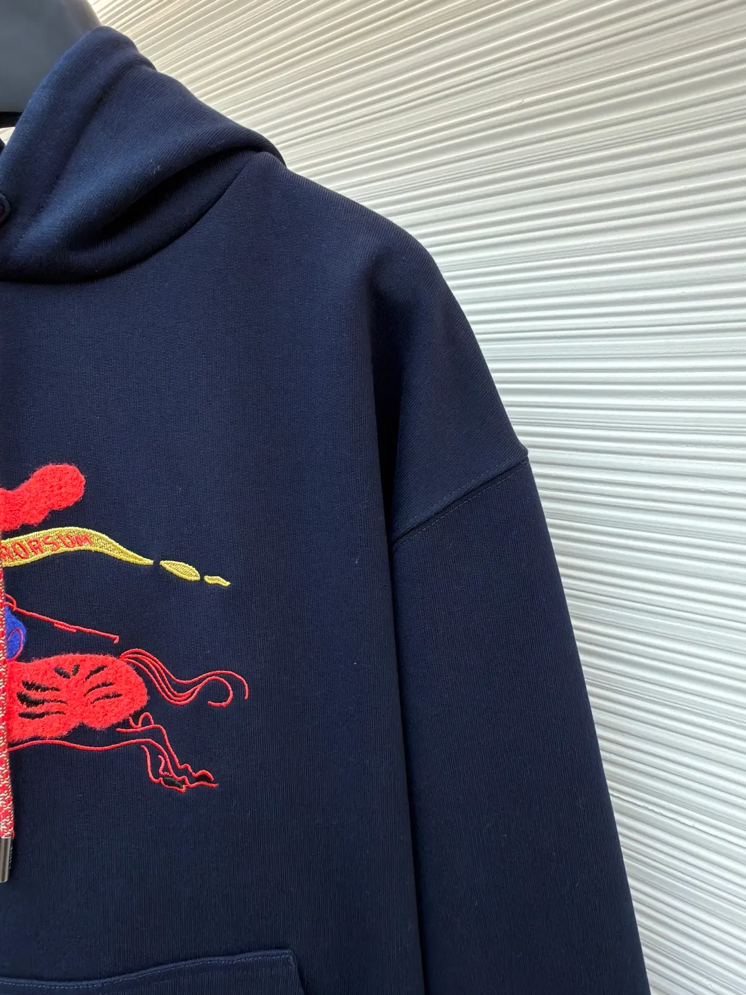 Burberry fleece horse embroidery hooded sweatshirt ●Original version: purchased and developed by 6239 ●Item number: 1682178-B05 ●Fabric: turned velvet cotton ●Technology: embroidery production ●Color: navy ●Version: fitted version ●Weight: about 1005 grams ●Size: XS-S-M-L ●Description: It adopts an inside-out velvet structure of 16-count double yarn on the top and 10-count yarn on the bottom, with a weight of up to 470g/㎡. It is matched with 21 double yarns and 1x1 rib, and the weight is 470g/㎡, ensuring that the cuffs, hem and other parts have unparalleled thickness and resilience, and the texture is unified and strong with the body. This is a special sweatshirt fabric that is ultra-heavy and high-density. Its inverted pile process means that the terry layer that is usually on the inside is turned over to the outside as the surface, and is finely brushed to directly present the appearance and feel of exceptionally rich, dense and soft pile, while the inside is relatively smooth. Metallic yarn embroidery: craftsmanship with plush effect, new season equestrian knight logo embroidery, and metallic yarn with a rich touch is the core of the design. During the embroidery process, a mixture of special yarns containing metallic threads is used, and through computer embroidery machine programming, the metallic yarns are integrated into specific parts of the pattern using stitching methods such as chain embroidery and tatami embroidery. On top of the traditional three-dimensional sense of embroidery, a shimmering metallic luster and a special cool touch are added, causing the classic logo pattern to produce local highlights under the light, showing a reshaped modern feel and a high-end customization-like sophistication, making it highly recognizable. The overall wiring is straight and delicate, the fabric is comfortable and soft, and the color is consistent without color difference. It can be matched with the same style to create a fashionable look and control various occasions. Customized accessories, complete with three standards, same style for men and women!
