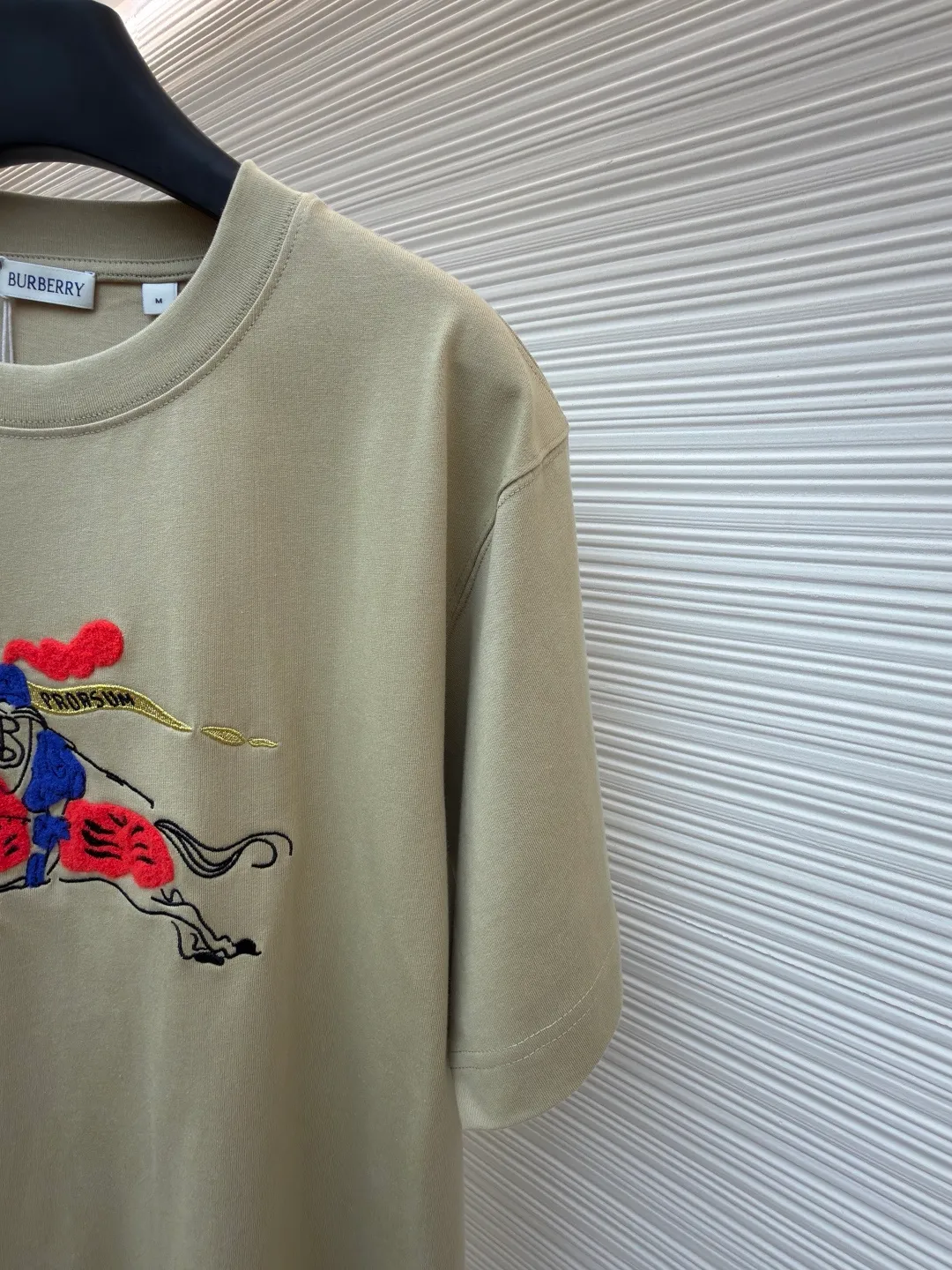 Burberry fleece pony round neck short sleeves ●Original version: Purchased and developed for 4850 ●Item number: 1682161-A05 ●Fabric: pure cotton plain weave ●Technology: embroidery production ●Color: khaki ●Version: fitted version ●Weight: about 290g ●Size: XS-S-M-L ●Description: Made of 15S fine cotton plain weave, 230g; matching 32S double yarn rack thread, 340g. Fine cotton fabrics usually have better moisture absorption, breathability, wear resistance, and are also softer and smoother. Vintage fine cotton fabric is a relatively thick cotton fabric that has been carefully processed and treated to have excellent texture and performance. It feels soft and comfortable and fits the skin very well when worn. Craftsmanship with plush effect, new season equestrian knight logo embroidery, and metallic yarns with a rich touch are the core of the design. During the embroidery process, special yarns containing metallic threads are mixed and programmed through a computer embroidery machine to integrate the metallic yarns into specific parts of the pattern using stitching methods such as chain embroidery and tatami embroidery. On top of the traditional three-dimensional sense of embroidery, a shimmering metallic luster and a special cool touch are added, causing the classic logo pattern to produce local highlights under light, showing a reshaped modern sense and a high-end customization-like sophistication, which is highly recognizable. The overall wiring is straight and delicate, the fabric is comfortable and soft, and the color is consistent without color difference. It can be matched with the same style to create a fashionable look and control various occasions. Customized accessories, complete with three standards, same style for men and women!