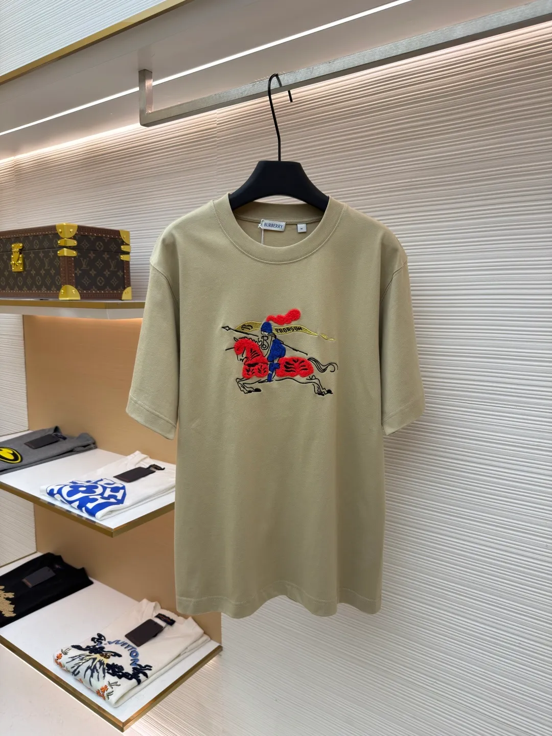 Burberry fleece pony round neck short sleeves ●Original version: Purchased and developed for 4850 ●Item number: 1682161-A05 ●Fabric: pure cotton plain weave ●Technology: embroidery production ●Color: khaki ●Version: fitted version ●Weight: about 290g ●Size: XS-S-M-L ●Description: Made of 15S fine cotton plain weave, 230g; matching 32S double yarn rack thread, 340g. Fine cotton fabrics usually have better moisture absorption, breathability, wear resistance, and are also softer and smoother. Vintage fine cotton fabric is a relatively thick cotton fabric that has been carefully processed and treated to have excellent texture and performance. It feels soft and comfortable and fits the skin very well when worn. Craftsmanship with plush effect, new season equestrian knight logo embroidery, and metallic yarns with a rich touch are the core of the design. During the embroidery process, special yarns containing metallic threads are mixed and programmed through a computer embroidery machine to integrate the metallic yarns into specific parts of the pattern using stitching methods such as chain embroidery and tatami embroidery. On top of the traditional three-dimensional sense of embroidery, a shimmering metallic luster and a special cool touch are added, causing the classic logo pattern to produce local highlights under light, showing a reshaped modern sense and a high-end customization-like sophistication, which is highly recognizable. The overall wiring is straight and delicate, the fabric is comfortable and soft, and the color is consistent without color difference. It can be matched with the same style to create a fashionable look and control various occasions. Customized accessories, complete with three standards, same style for men and women!