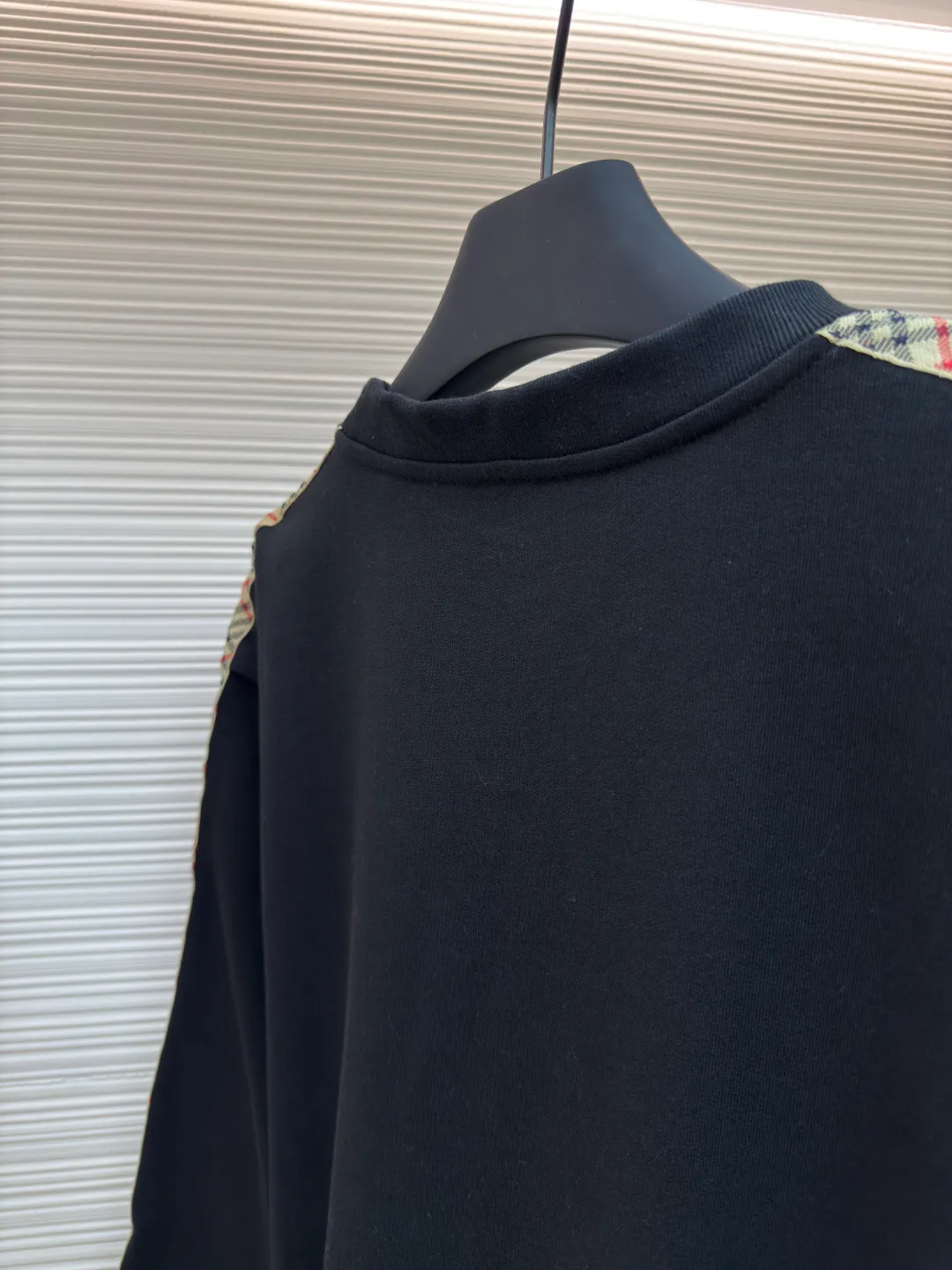 BURBERRY webbing trim round neck sweatshirt ●Authentic product: purchased and developed by 6143 ●Item number: 1680513-A85 ●Fabric: single-sided fish scale fabric ●Technology: selvedge production ●Version: fitted version ●Weight: about 666 grams ●Size: S-M-L-XL ●Description: A single-sided fish-scale cloth fabric woven with cotton as the base. The front is a smooth knitted surface, and the skin-contacting surface is formed into three-dimensional terry by the floating thread knitting technology of the knitting machine, which increases the fluffiness and has a delicate touch. The terry structure absorbs a large amount of water and evaporates quickly, so it is not easy to loosen and deform after repeated washing. By actively interfering with the shrinkage potential of cotton fibers, the fabric is able to transition from changeable to stable, improving dimensional stability while being less prone to deformation and wrinkles. The monochrome flat embroidery on the chest uses the high-precision calculation system of the computer embroidery machine to control the coordinated operation of the machine head, needle bar, and thread spool. The fabric frame moves accurately in the horizontal and vertical directions to form a stitch track. The upper and lower thread tensions are adjusted to ensure that the stitches are smooth and free of floating threads, forming a fine pattern with an error of ±0.1mm. The overall wiring is straight and delicate, the fabric is comfortable and soft, and the color is consistent without color difference. It can be matched with the same style to create a fashionable look and control various occasions. Customized accessories, complete with three standards, same style for men and women!