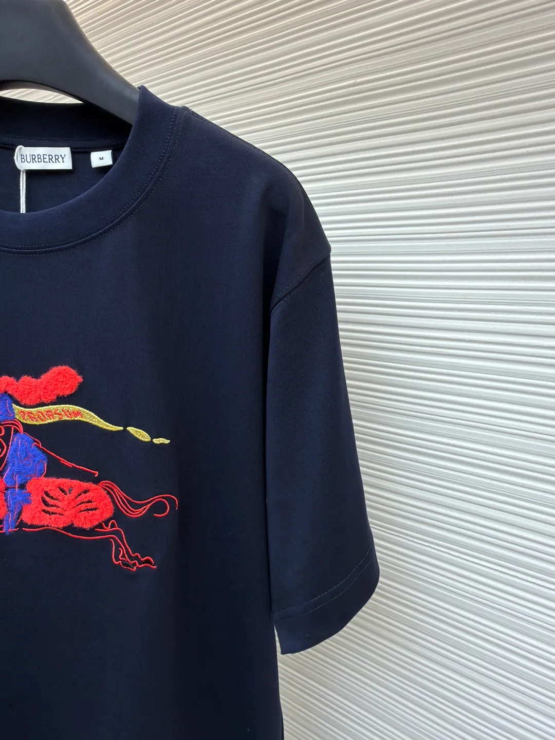 Burberry fleece pony round neck short sleeves ●Original version: Purchased and developed for 4850 ●Item number: 1682163-A05 ●Fabric: pure cotton plain weave ●Technology: embroidery production ●Color: navy blue ●Version: fitted version ●Weight: about 265g ●Size: XS-S-M-L ●Description: Made of 15S fine cotton plain weave, 230g; matching 32S double yarn rack thread, 340g. Fine cotton fabrics usually have better moisture absorption, breathability, wear resistance, and are also softer and smoother. Vintage fine cotton fabric is a relatively thick cotton fabric that has been carefully processed and treated to have excellent texture and performance. It feels soft and comfortable and fits the skin very well when worn. Craftsmanship with plush effect, new season equestrian knight logo embroidery, and metallic yarns with a rich touch are the core of the design. During the embroidery process, special yarns containing metallic threads are mixed and programmed through a computer embroidery machine to integrate the metallic yarns into specific parts of the pattern using stitching methods such as chain embroidery and tatami embroidery. On top of the traditional three-dimensional sense of embroidery, a shimmering metallic luster and a special cool touch are added, causing the classic logo pattern to produce local highlights under light, showing a reshaped modern sense and a high-end customization-like sophistication, which is highly recognizable. The overall wiring is straight and delicate, the fabric is comfortable and soft, and the color is consistent without color difference. It can be matched with the same style to create a fashionable look and control various occasions. Customized accessories, complete with three standards, same style for men and women!