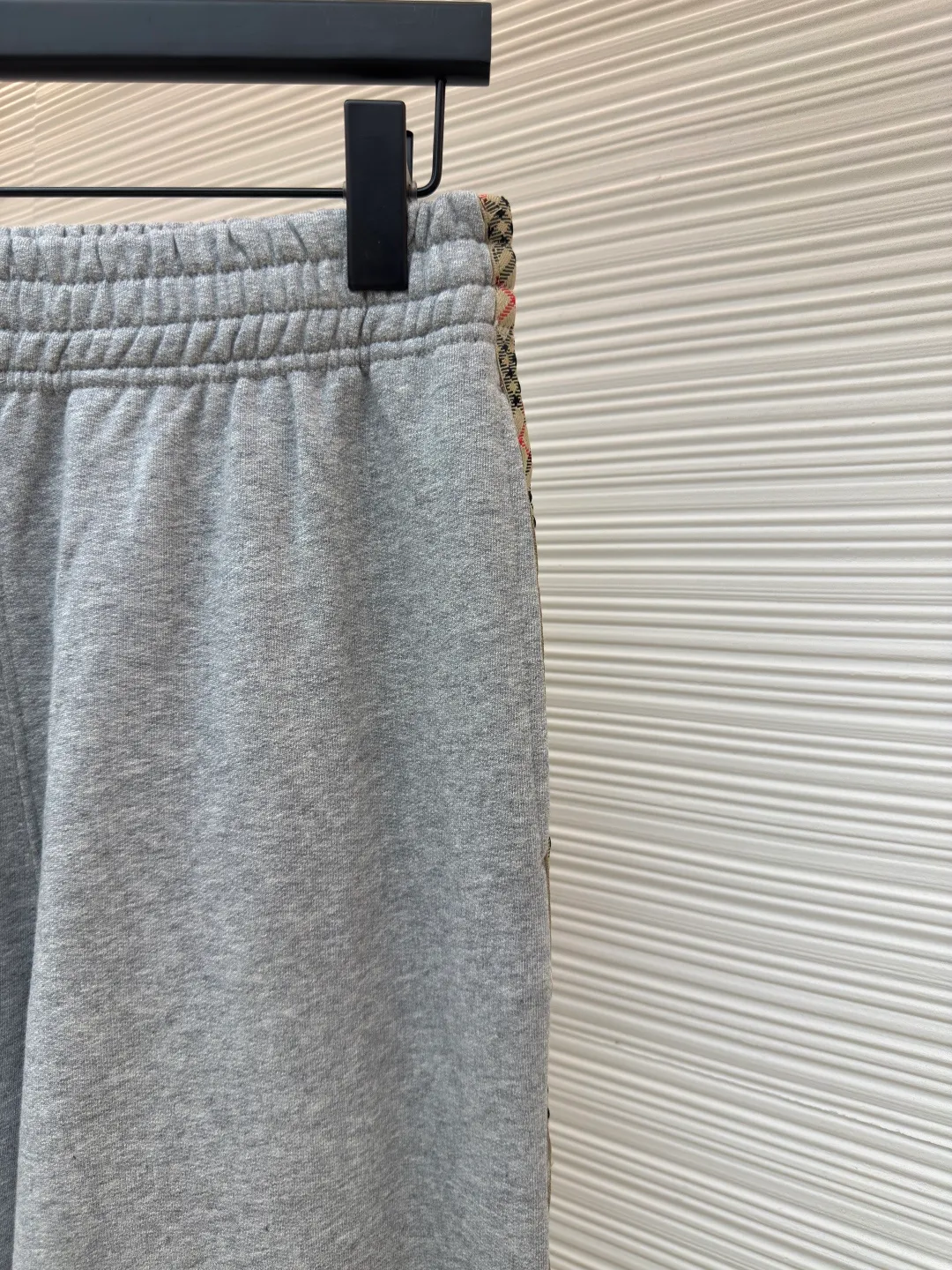 BURBERRY plaid webbing embroidered sweatpants ●Authentic product: purchased and developed by 5202 ●Item number: 1680515-A95 ●Fabric: single-sided fish scale fabric ●Technology: selvage production ●Version: fitted version ●Weight: about 705 grams ●Size: S-M-L-XL ●Description: A single-sided fish-scale cloth fabric woven with cotton as the base. The front is a smooth knitted surface, and the skin-contacting surface is formed into three-dimensional terry by the floating thread knitting technology of the knitting machine, which increases the fluffiness and has a delicate touch. The terry structure absorbs a large amount of water and evaporates quickly, so it is not easy to loosen and deform after repeated washing. By actively interfering with the shrinkage potential of cotton fibers, the fabric is able to transition from changeable to stable, improving dimensional stability while being less prone to deformation and wrinkles. The monochrome flat embroidery on the chest uses the high-precision calculation system of the computer embroidery machine to control the coordinated operation of the machine head, needle bar, and thread spool. The fabric frame moves accurately in the horizontal and vertical directions to form a stitch track. The upper and lower thread tensions are adjusted to ensure that the stitches are smooth and free of floating threads, forming a fine pattern with an error of ±0.1mm. The overall wiring is straight and delicate, the fabric is comfortable and soft, and the color is consistent without color difference. It can be matched with the same style to create a fashionable look and control various occasions. Customized accessories, complete with three standards, same style for men and women!