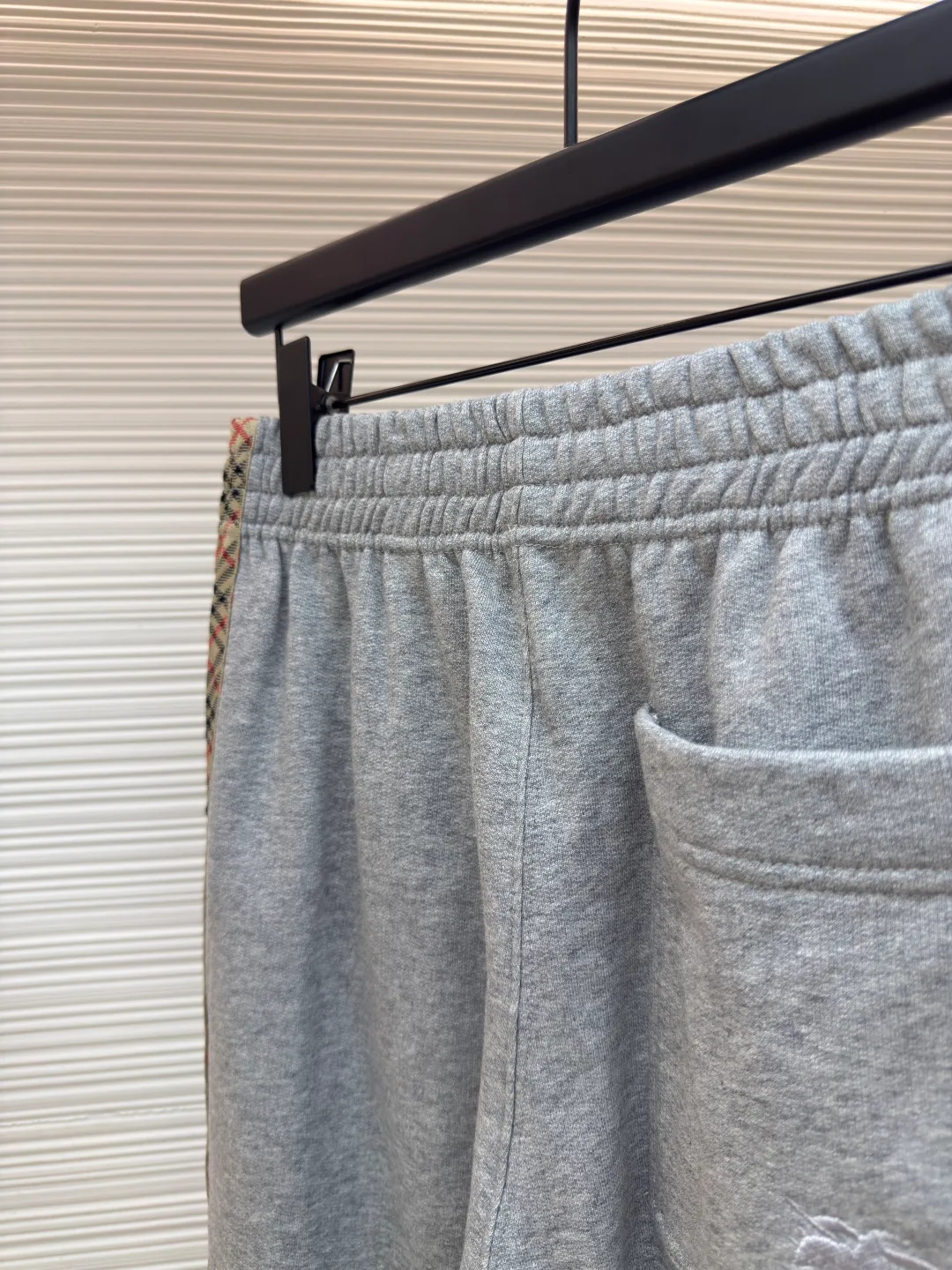 BURBERRY plaid webbing embroidered sweatpants ●Authentic product: purchased and developed by 5202 ●Item number: 1680515-A95 ●Fabric: single-sided fish scale fabric ●Technology: selvage production ●Version: fitted version ●Weight: about 705 grams ●Size: S-M-L-XL ●Description: A single-sided fish-scale cloth fabric woven with cotton as the base. The front is a smooth knitted surface, and the skin-contacting surface is formed into three-dimensional terry by the floating thread knitting technology of the knitting machine, which increases the fluffiness and has a delicate touch. The terry structure absorbs a large amount of water and evaporates quickly, so it is not easy to loosen and deform after repeated washing. By actively interfering with the shrinkage potential of cotton fibers, the fabric is able to transition from changeable to stable, improving dimensional stability while being less prone to deformation and wrinkles. The monochrome flat embroidery on the chest uses the high-precision calculation system of the computer embroidery machine to control the coordinated operation of the machine head, needle bar, and thread spool. The fabric frame moves accurately in the horizontal and vertical directions to form a stitch track. The upper and lower thread tensions are adjusted to ensure that the stitches are smooth and free of floating threads, forming a fine pattern with an error of ±0.1mm. The overall wiring is straight and delicate, the fabric is comfortable and soft, and the color is consistent without color difference. It can be matched with the same style to create a fashionable look and control various occasions. Customized accessories, complete with three standards, same style for men and women!