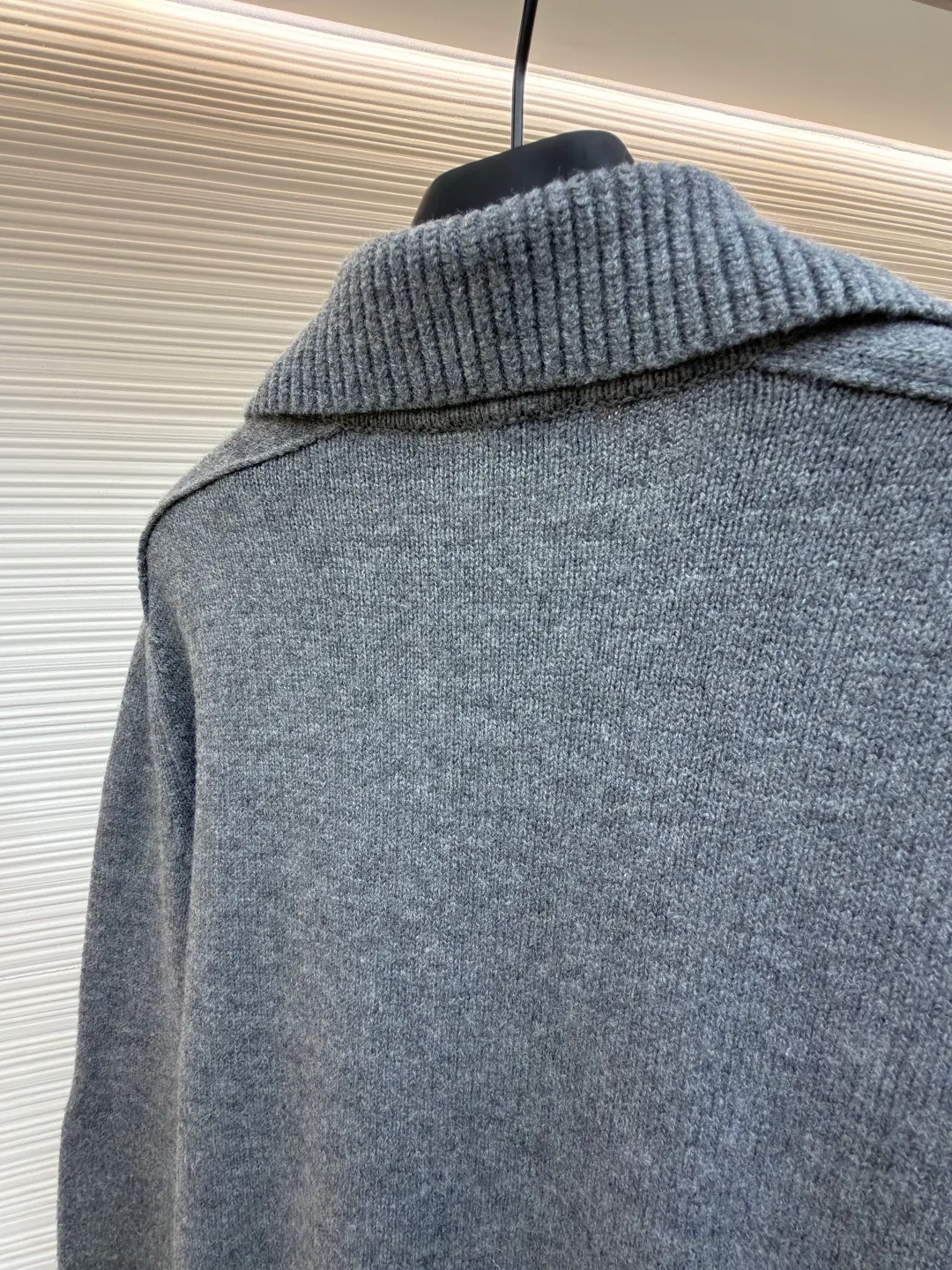 Burberry lapel rib knitted cashmere sweater ●Original version: purchased and developed by 11575 ●Item number: 1682227-B15 ●Fabric: wool blended fabric ●Technology: knitted ●Color: gray ●Version: fitted version ●Weight: about 580 grams ●Size: S-M-L-XL ●Description: This black knitted cardigan is knitted with high-count worsted wool yarn. The main body is built using four-flat stitch technology, which gives the fabric good elasticity and shapeability, while forming a fine and tight texture. The ribbed lapel weaving process is used at the neckline, and a combination of different needle types is used to create a crisp collar profile. The rib structure can be freely expanded and contracted according to the wearing status to fit the neck line. The placket adopts inlaid buttonhole technology and is matched with matte resin buttons of the same color. The buttons and the body are fixed by hand-stitching, which is strong and beautiful. The brand logo patch on the lower side of the body is processed by a hot-pressing bonding process and fits seamlessly with the knitted fabric. The overall cut is a slightly loose shoulder-drop version, combined with three-dimensional darting technology, which ensures wearing comfort while creating clean lines. Every knitting node is manually inspected to ensure the uniformity and integrity of the knitted texture. The overall wiring is straight and delicate, the fabric is comfortable and soft, and the color is consistent without color difference. It can be matched with the same style to create a fashionable look and control various occasions. Customized accessories, complete with three standards, same style for men and women!