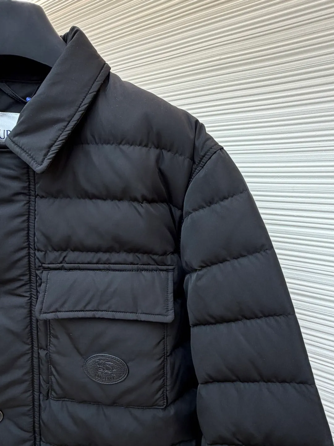 Burberry light leather label down jacket ●Original version: purchased and developed by 6125 ●Item number: 1681878-C95 ●Fabric: white duck down fabric ●Technology: mechanical down filling ●Color: black ●Version: fitted version ●Weight: about 790 grams ●Size: S-M-L-XL ●Description: High-density nylon taffeta: Made of 100D nylon fabric, density ≥230T, durable Slightly calendered (showing low-key luster), and fluorine-free waterproof coating (DWR) to ensure water repellency while maintaining breathability (refer to the slightly wrinkled texture and stiffness of the fabric in the picture) Anti-velvet gallbladder: Use high-density polyester gallbladder cloth (such as gallbladder silk spinning) above 300T to ensure that the down does not rip through velvet, and is light and thin without affecting the fluffiness. Filling 900-fill white duck down (85%-90% down content) ensures a full three-dimensional effect but not too bloated. It uses YKK brand No. 5 nylon zipper (matte dark gray/black, close to the fabric). The zipper teeth are fine-toothed and flat-toothed. The puller is simple and square. The brand logo is etched on the surface. The outside of the zipper needs to be seamed. 1.5cm wide windproof placket made of the same color fabric (double-layered, with thin cotton strips sandwiched inside to increase stiffness). The cuffs are fake two-piece design (the outer layer is folded cuffs, and the inner layer is ribbed). The outer cuffs are equipped with 2 metal buttons (diameter 12mm, the same series as the pocket snaps), with a spacing of 3cm. The buttonholes are hand-made keyholes (double-line seaming, precise aperture). They are made of first-layer calfskin (thickness 0.8-mm). The leather surface is matte aniline dyed and the edges are warped. Oil edge treatment (thickness 0.3mm, round and smooth, color consistent with leather label). The brand pattern (knight logo + text) on the surface of the leather label adopts embossing + hot stamping/silvering technology. The overall wiring is straight and delicate, the fabric is comfortable and soft, and the color is consistent without color difference. It can be matched with the same style to create a fashionable look and control various occasions. Customized accessories, complete with three labels, same style for men and women!