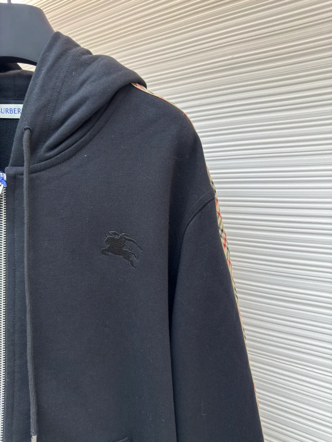 BURBERRY webbing trim embroidered hooded sweatshirt ●Authentic product: purchased and developed by 3610 ●Item number: 1680519-B50 ●Fabric: single-sided fish scale fabric ●Technology: selvedge production ●Version: fitted version ●Weight: about 950 grams ●Size: S-M-L-XL ●Description: Made of cotton as the main body, fed with 6% polyester fiber and 2% elastic fiber blend. Cotton fiber is naturally skin-friendly, soft, and highly absorbent. Its structural properties preserve the breathability of the fabric and reduce stuffiness. The addition of a small amount of elastic fiber and polyester fiber significantly improves the stretch and resilience of the fabric, while also enhancing wrinkle resistance and shape retention, and reducing shrinkage. Plaid lines form a looming relief effect through the changes in yarn color and weave, which are smooth to the touch but rich in visual layers. The jacquard process weaves the pattern into the bone, making it resistant to fading and wear and tear after repeated washing. Precise cutting and positioning cutting machine: Use positioning cutting machine equipment to accurately cut fabrics, and improve the overall quality through optical positioning and mechanical positioning. Ensure that every product meets the high standards of alignment and alignment. The overall wiring is straight and delicate, the fabric is comfortable and soft, and the color is consistent without color difference. It can be matched with the same style to create a fashionable look and control various occasions. Customized accessories, complete with three standards, same style for men and women!