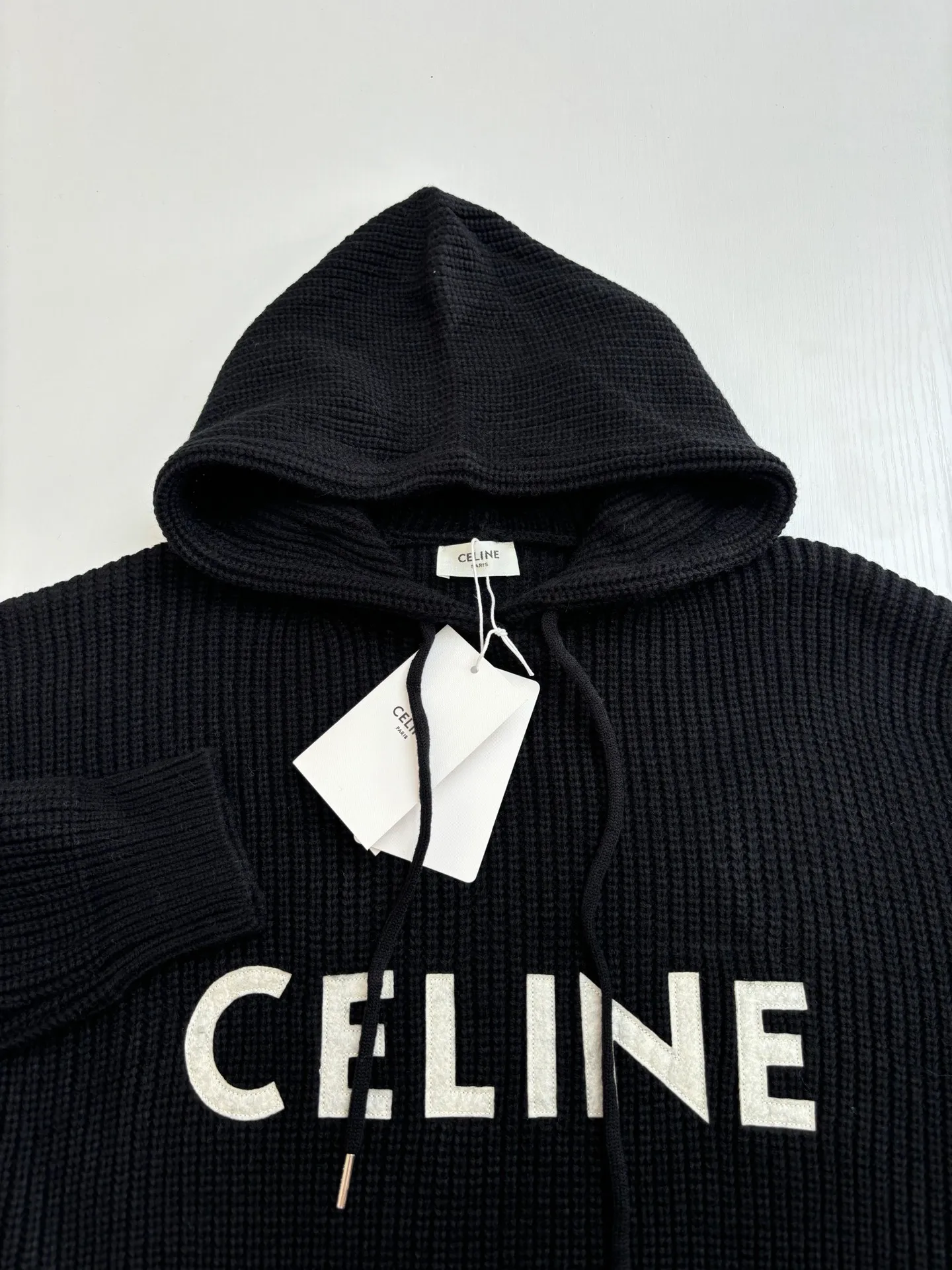 🅿️480 Celine*/Celine 25FW patch hooded sweater. The fabric is made of 75 wool 25 Angora rabbit fur that is closest to the original version. It is made of customized expanded blended wool. The upper body is comfortable and soft, and the weight is 700 grams. It is made of imported Stoll weaving with clear texture and 7-needle double ingot stitching method. The imported thickened felt cloth on the front chest is embroidered with letters using laser embroidery technology. High-energy laser beams are used for fine cutting and embroidery on the fabric. The letter material is made of wool superfiber positioning laser embroidery, which combines the strength of wool. Natural softness and durability of microfiber, the laser beam is used to precisely embroider at designated positions to achieve a highly precise embroidery effect. The letters have smooth lines and clear edges. The felt must be washed after embroidery to make it fluffy and more coordinated with the clothes. Thin felt is used for embroidery on the market and cannot be washed. Custom letter engraved white asphalt alloy tail clip, custom woven and dyed cotton texture round rope Size: S/M/L