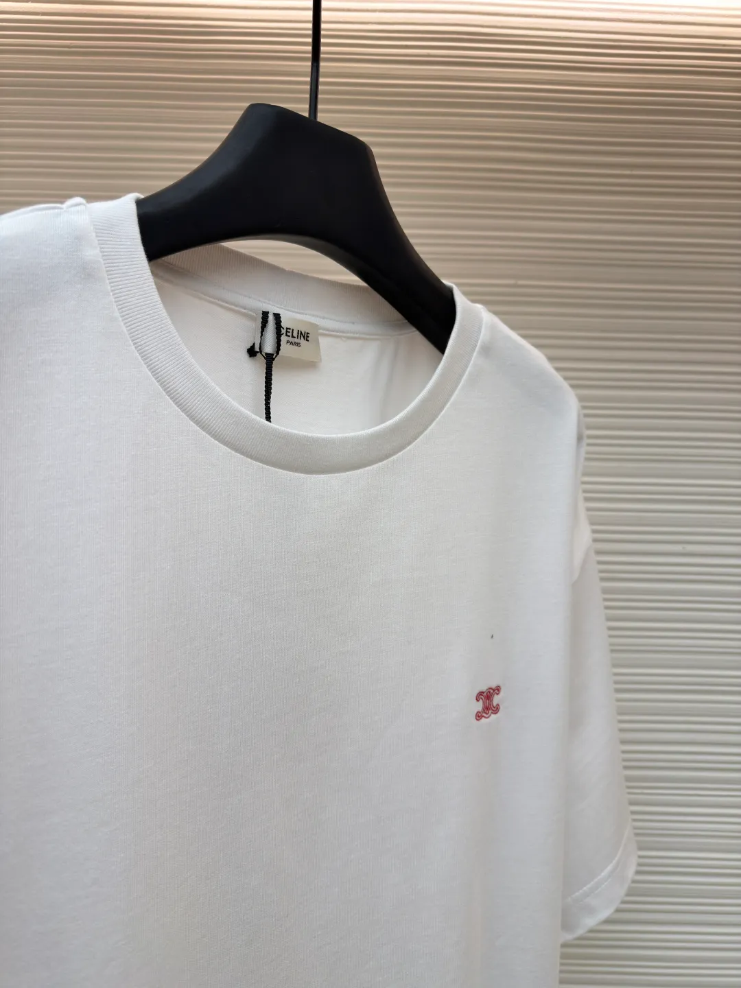 Celine Arc de Triomphe logo short sleeves ●Item number: 1682387-A00 ●Material: cotton fabric ●Technology: embroidery production ●Color: white ●Version: fitted version ●Weight: about 285 grams ●Size: XS-S-M-L ●Description: Made of 15-count special-spun compact cotton with a weight of 230g/㎡; 32-count high-weight (340g) 1x1 ribs are used for the neckline. Its high-count and high-weight characteristics ensure the excellent elastic recovery, thickness and deformation resistance of the collar. It is the key to ensuring that the neckline of the T-shirt does not deform after long-term wear. Specially woven compact cotton fabrics apply compact spinning technology in the spinning process, which effectively reduces yarn hairiness and makes the yarn smoother and stronger. This gives the fabric an unusually dense structure, a smooth and smooth surface, and excellent pilling resistance, while retaining the softness and breathability of pure cotton. The weight of 230g is medium to heavy, which ensures the T-shirt has good stiffness and drape, and is not easy to collapse and deform, laying a high-quality basic texture. The overall wiring is straight and delicate, the fabric is comfortable and soft, and the color is consistent without color difference. It can be matched with the same style to create a fashionable look and control various occasions. Customized accessories, complete with three standards, same style for men and women!
