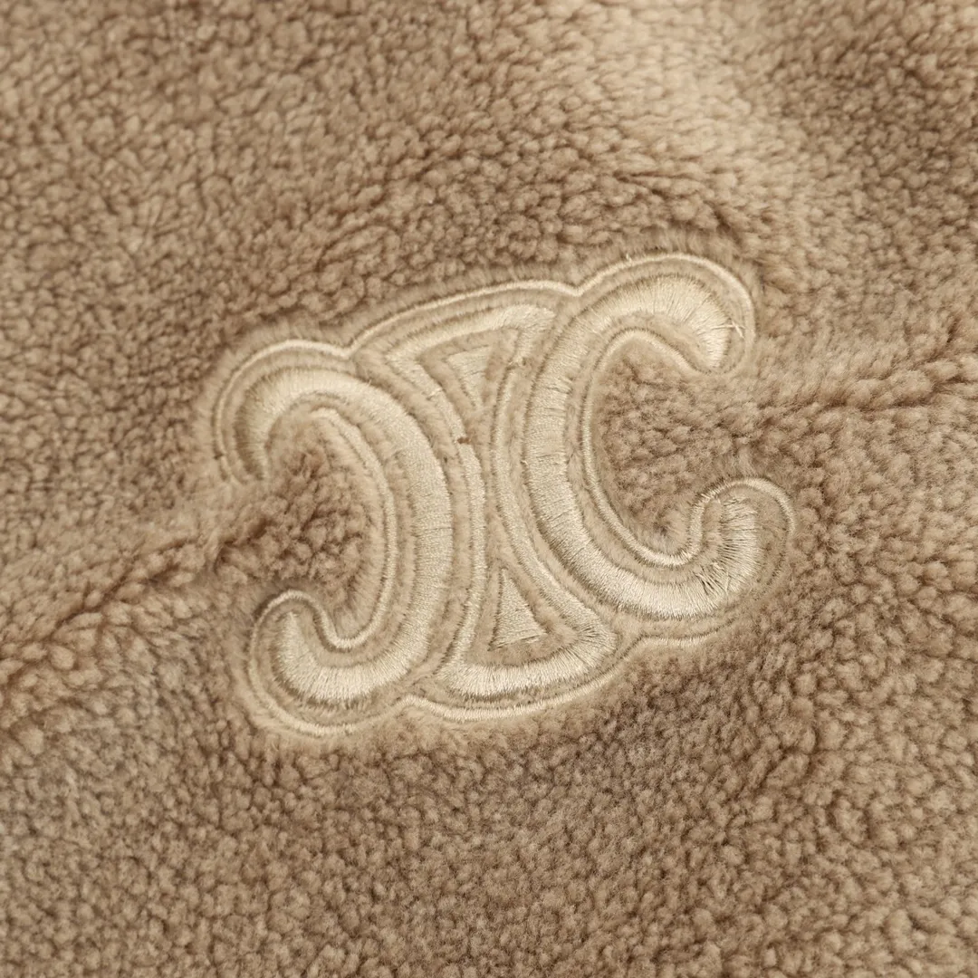 🅿️570 CELINE Arc de Triomphe Suede Cotton Jacket The polyester filament is passed through a circular knitting machine, and the warp and weft yarns are woven into each other into a double-sided knitted structure. The front and back are flat loops. The polar fleece fabric is formed after a series of processes such as dyeing, raising, carding, shearing, and polarization. The suede texture is soft and the fiber characteristics make it almost non-absorbent. It can quickly drain sweat to the outer layer of the fabric and evaporate quickly, maintaining good breathability. The suede surface can lock the air and form a stagnant air layer around the body, effectively preventing heat loss and providing good warmth retention properties. Using quilted cannage pattern, the seamstress precisely adjusts the speed of the machine and stitch density, so that the stitches are smooth and even during the operation. After completion, regular diagonal quilting lines will be formed, which will inadvertently enhance the overall texture when putting it on and taking it off. The fabric and padding material are tightly fixed to the frame of the embroidery machine. The embroidery machine uses sparse stitches along the padding layer's pattern to outline the filling area of ​​the pattern, and then runs the overlay layer's pattern, using dense stitches to perfectly cover the foam padding layer, thus forming a slightly raised Arc de Triomphe shape. After final finishing, the edges of the patch are burr-free and the pattern is clear. Size：XS-L